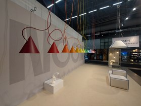 Noon Johanson hanging colourful lights, with white sofas at Noon's showroom.