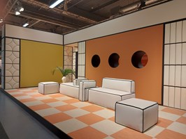 Showroom at Johanson with orange and white checked flooring, white sofas with black linings and acoustic panelling.