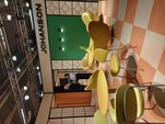 Johanson showroom orange and white checked floor, with yellow tables and chairs, acoustic panelling and designers talking.