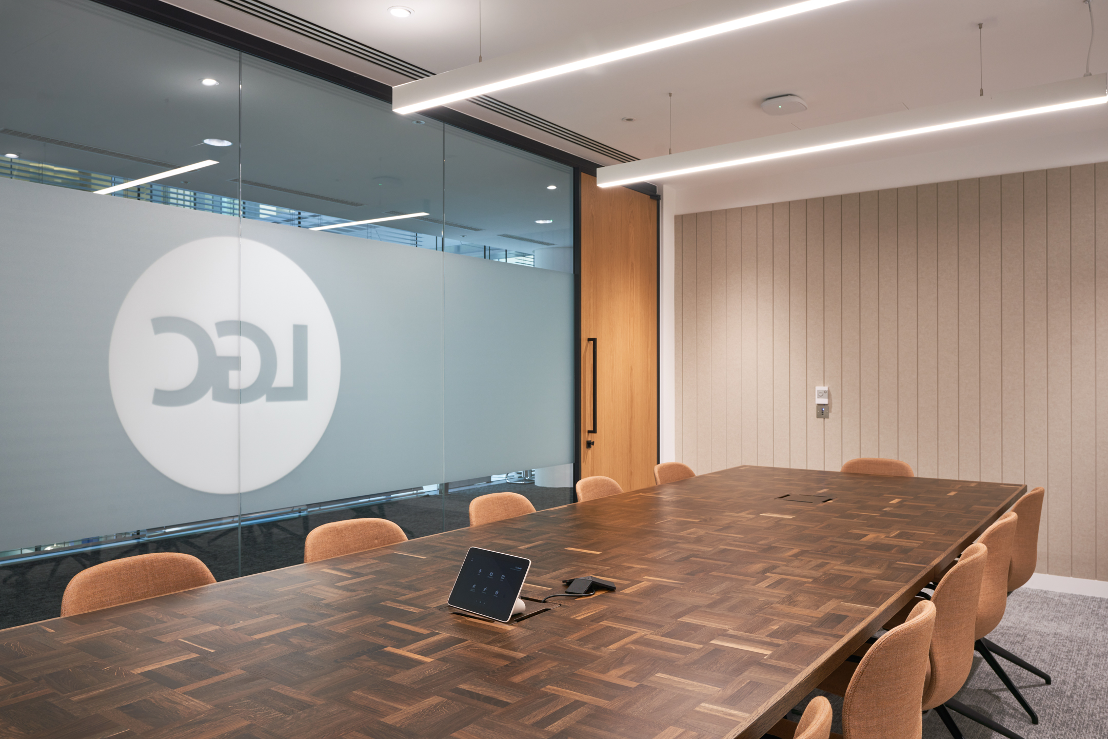LGC meeting room with custom wood-patterned table and ergonomic chairs supplied by Platfform.