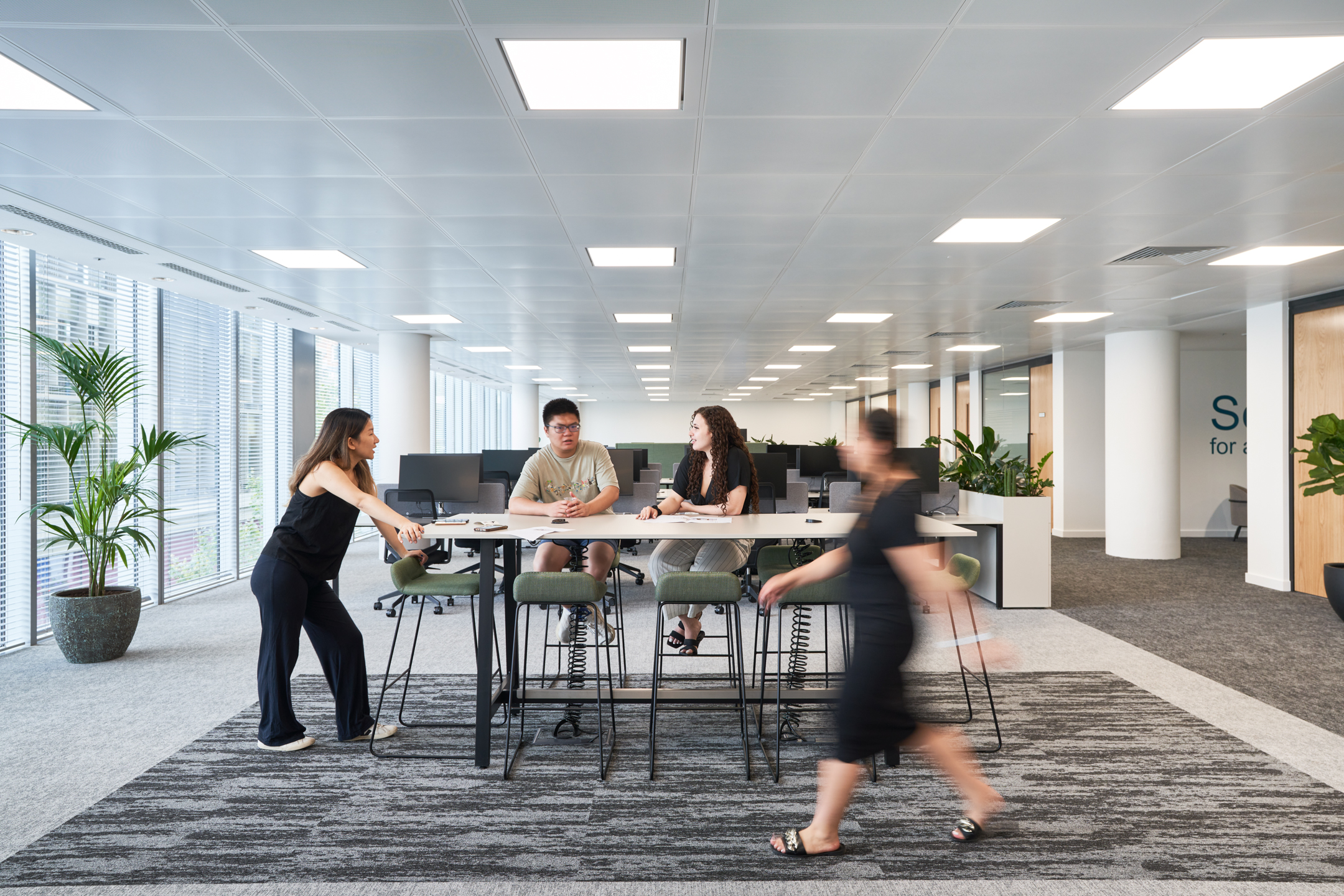 Collaborative working area at LGC with high tables, green upholstered stools and ergonomic task chairs, all supplied by Platfform.