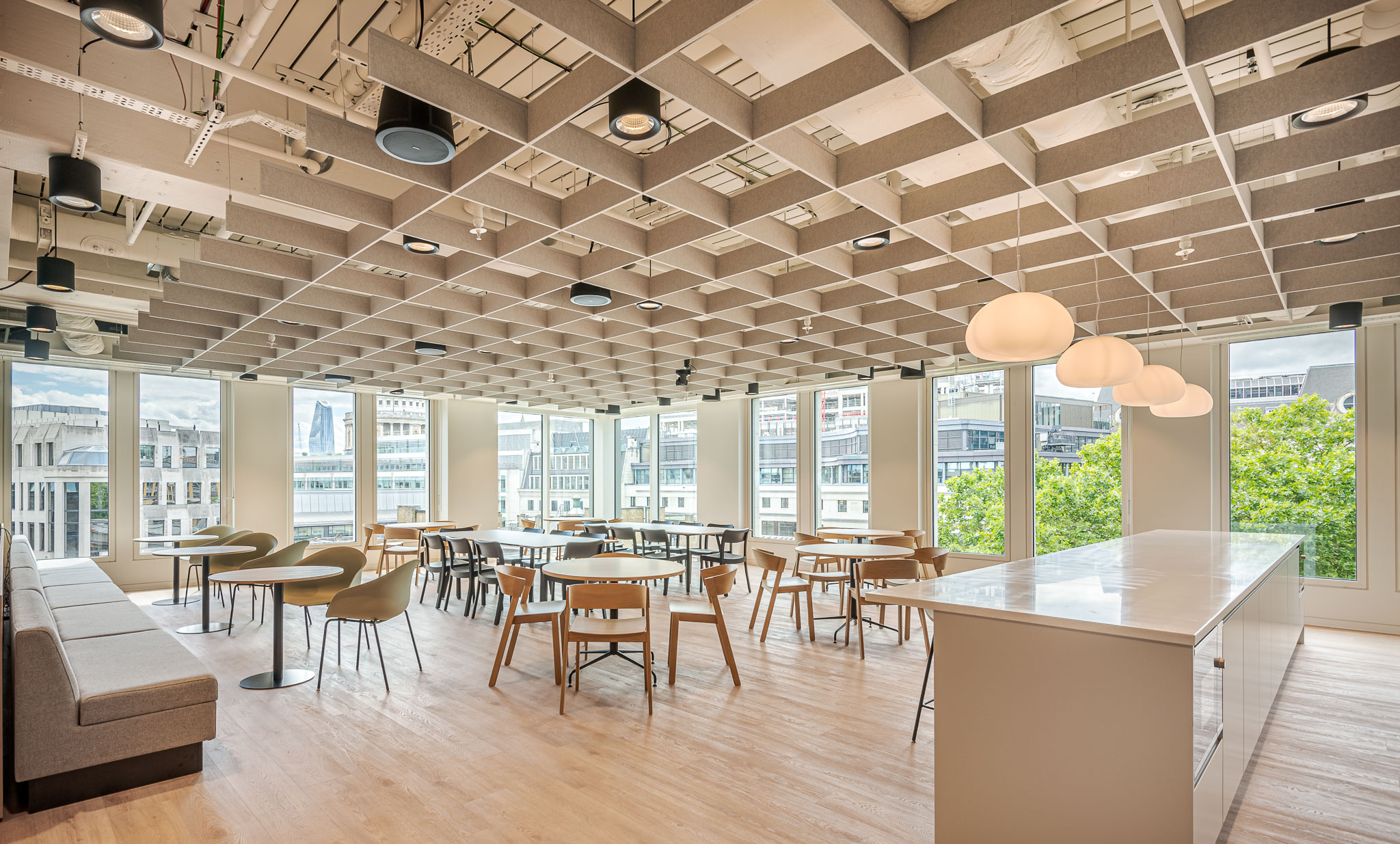 Bank of Ireland breakout and teapoint space with soft-toned furniture and a long marble island, designed to support informal meetings and team downtime.