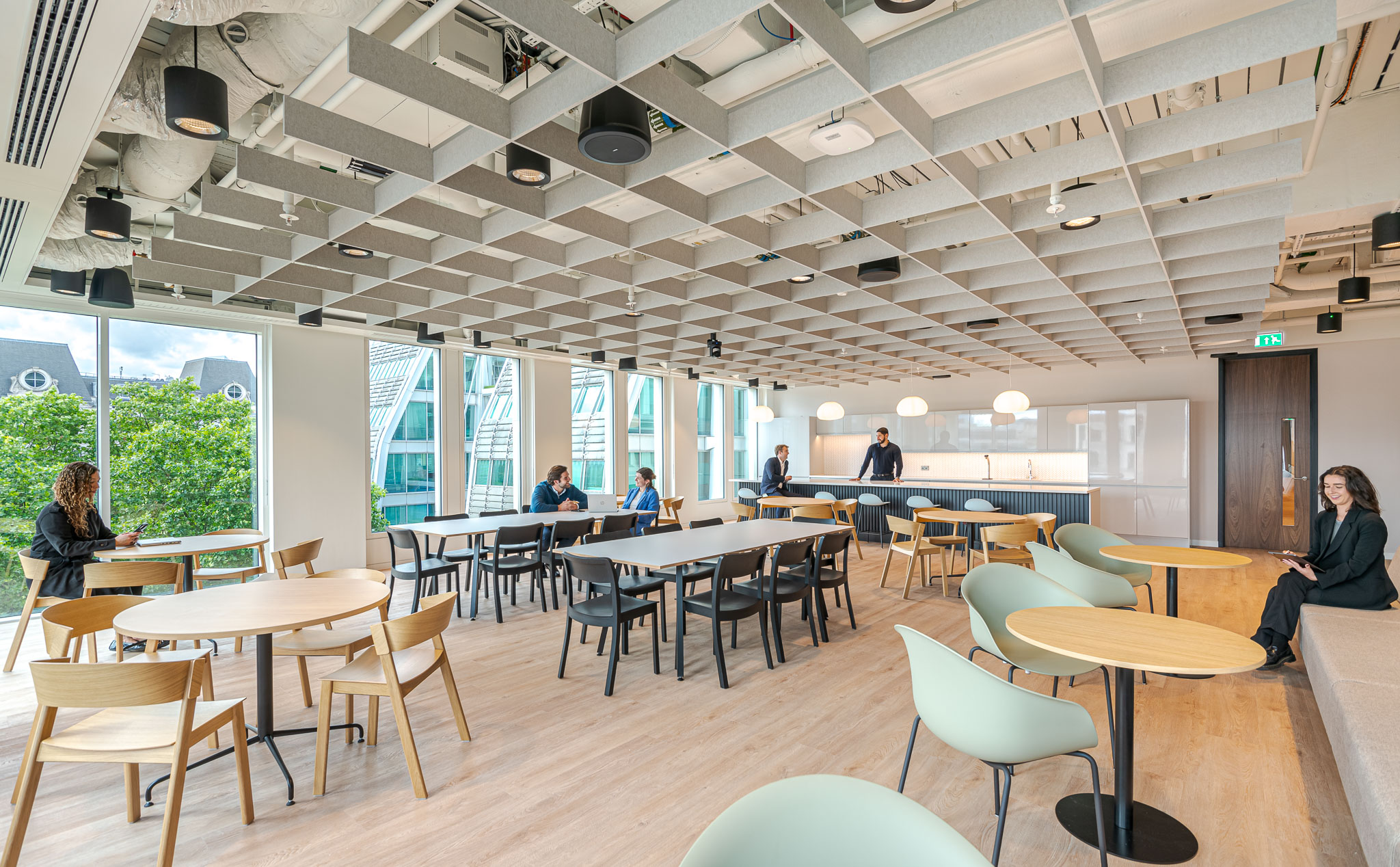 Bank of Ireland workplace café with a mix of soft seating and dining furniture, supporting informal collaboration and individual focus time.