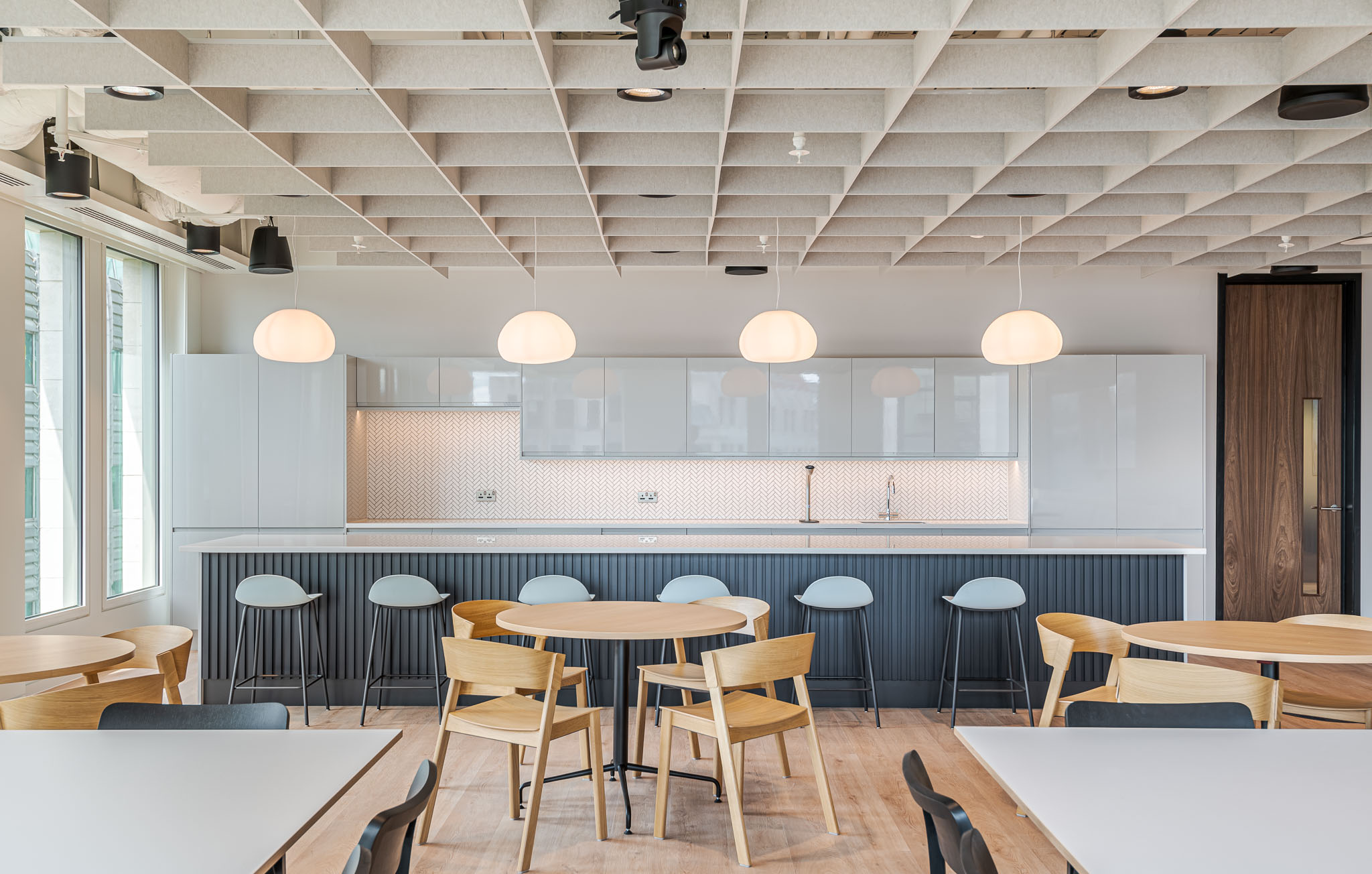 Bank of Ireland teapoint area with pale wood furniture and soft-toned stools, designed to support casual dining and social interaction.