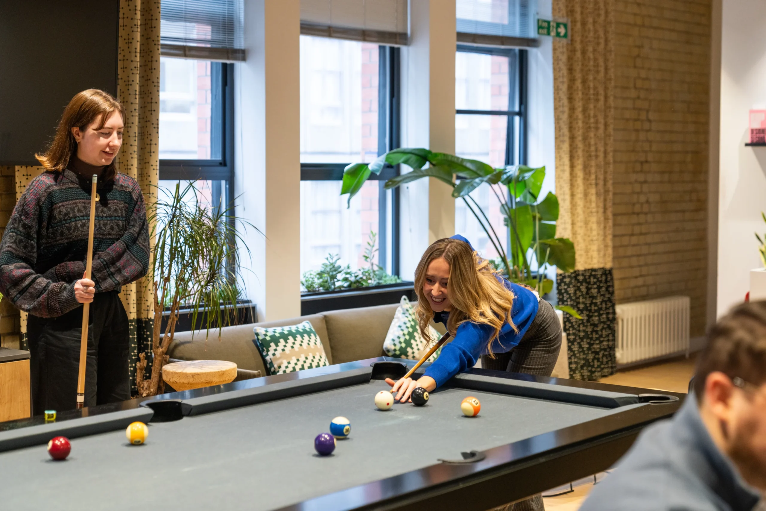 Some employees relax on a break by playing pool in the office