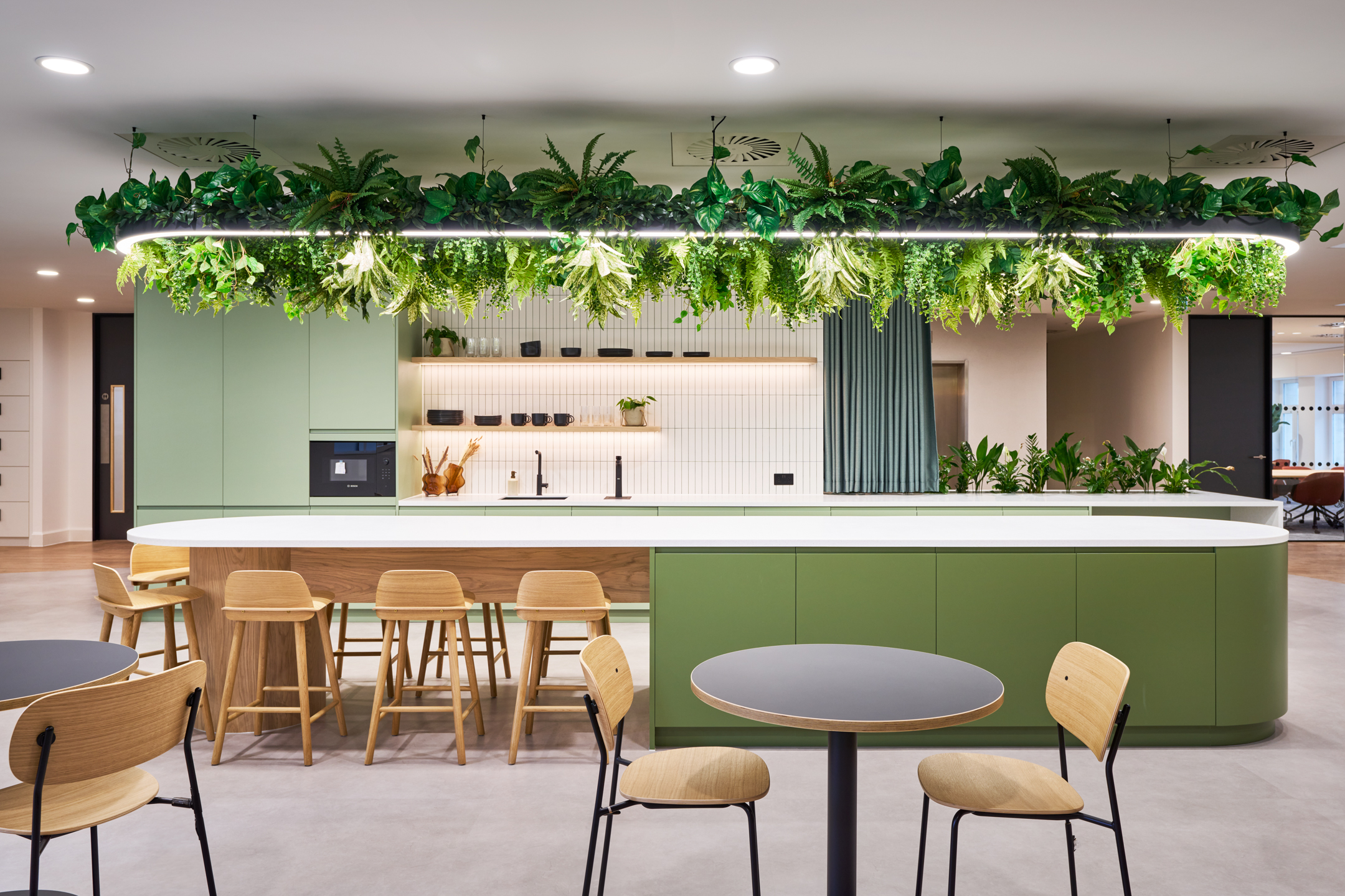 Green-accented workplace kitchen at 7 Bishopsgate, Level 4, furnished by Platfform for BGO, featuring integrated planting and natural wood finishes.