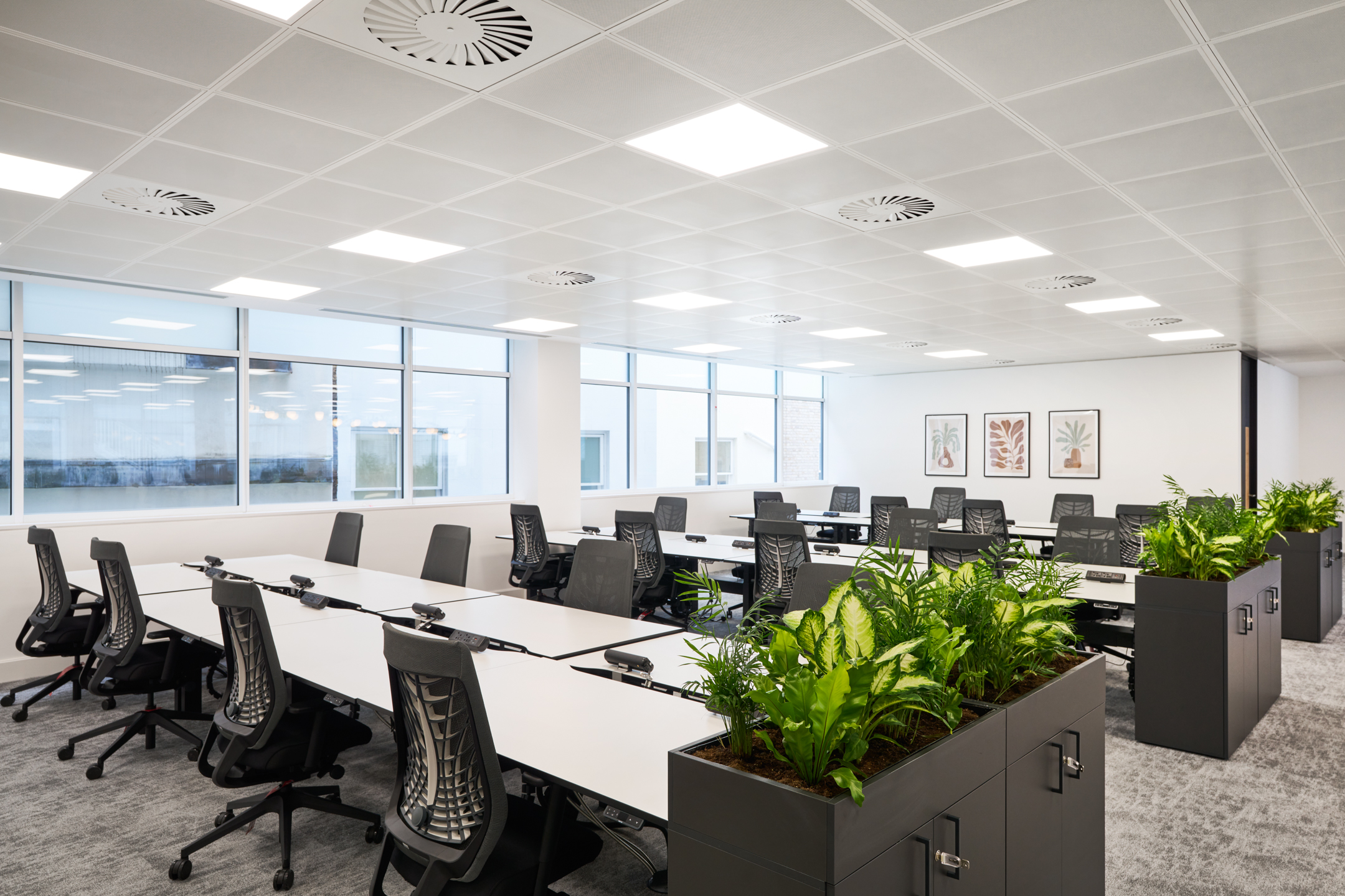 Open-plan desking at 7 Bishopsgate, Level 4, fitted out by Platfform for BGO, featuring ergonomic task chairs and integrated storage with lush planting.