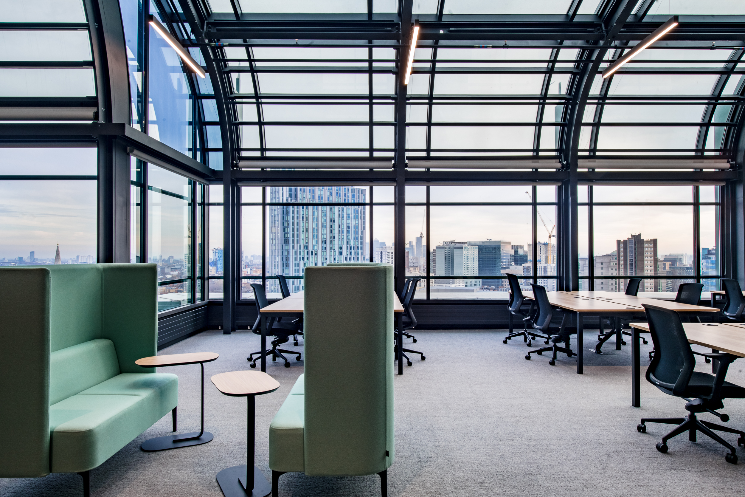 Office interior at 135 Bishopsgate with mint green high-back booths and shared desks, furnished by Platfform for British Land under a glazed arched roof.