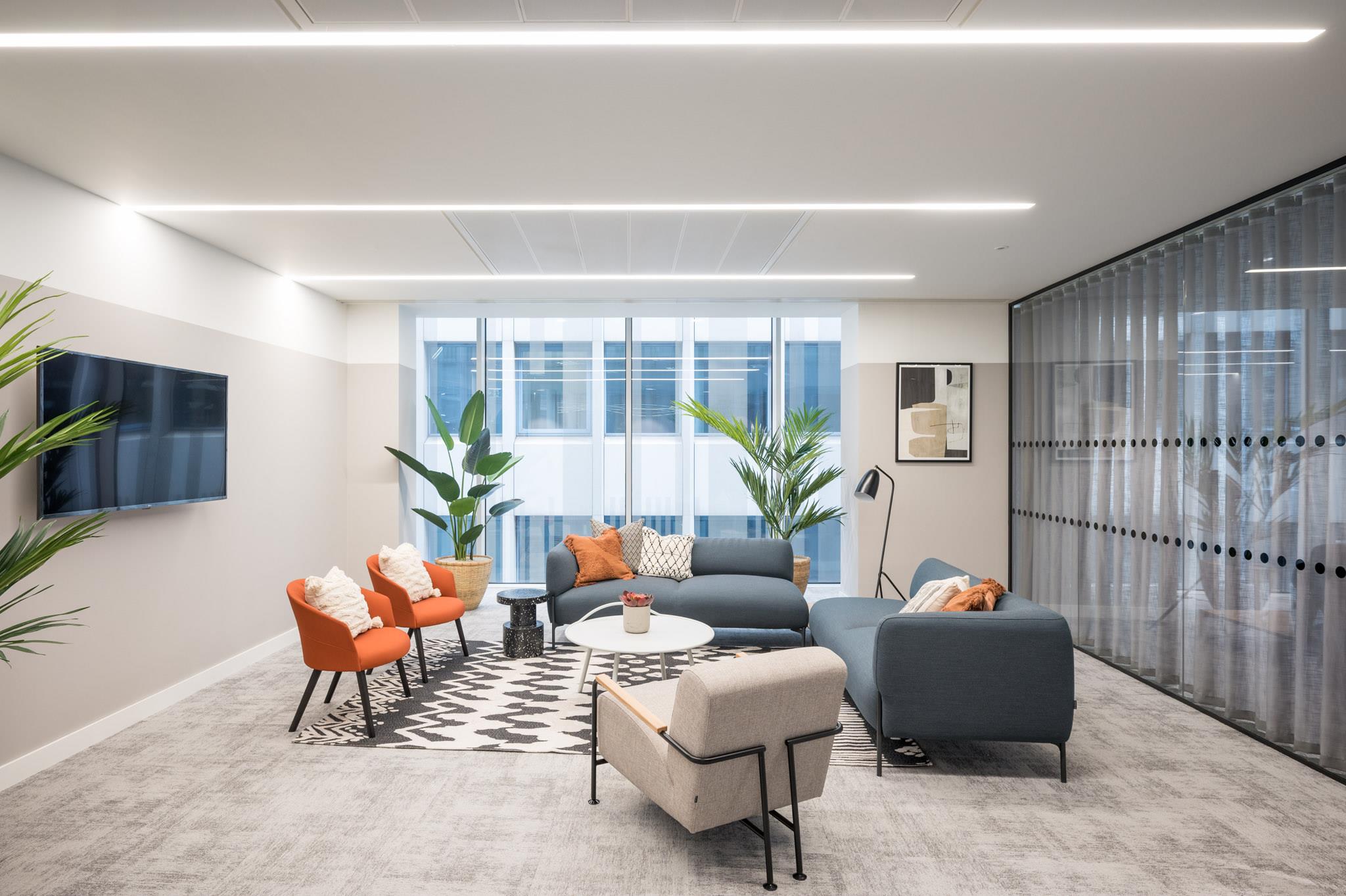 oft seating and bold accent walls at Platfform's 70 New Oxford Street project, featuring peach and teal booths with patterned wallpaper for a vibrant, modern breakout space.