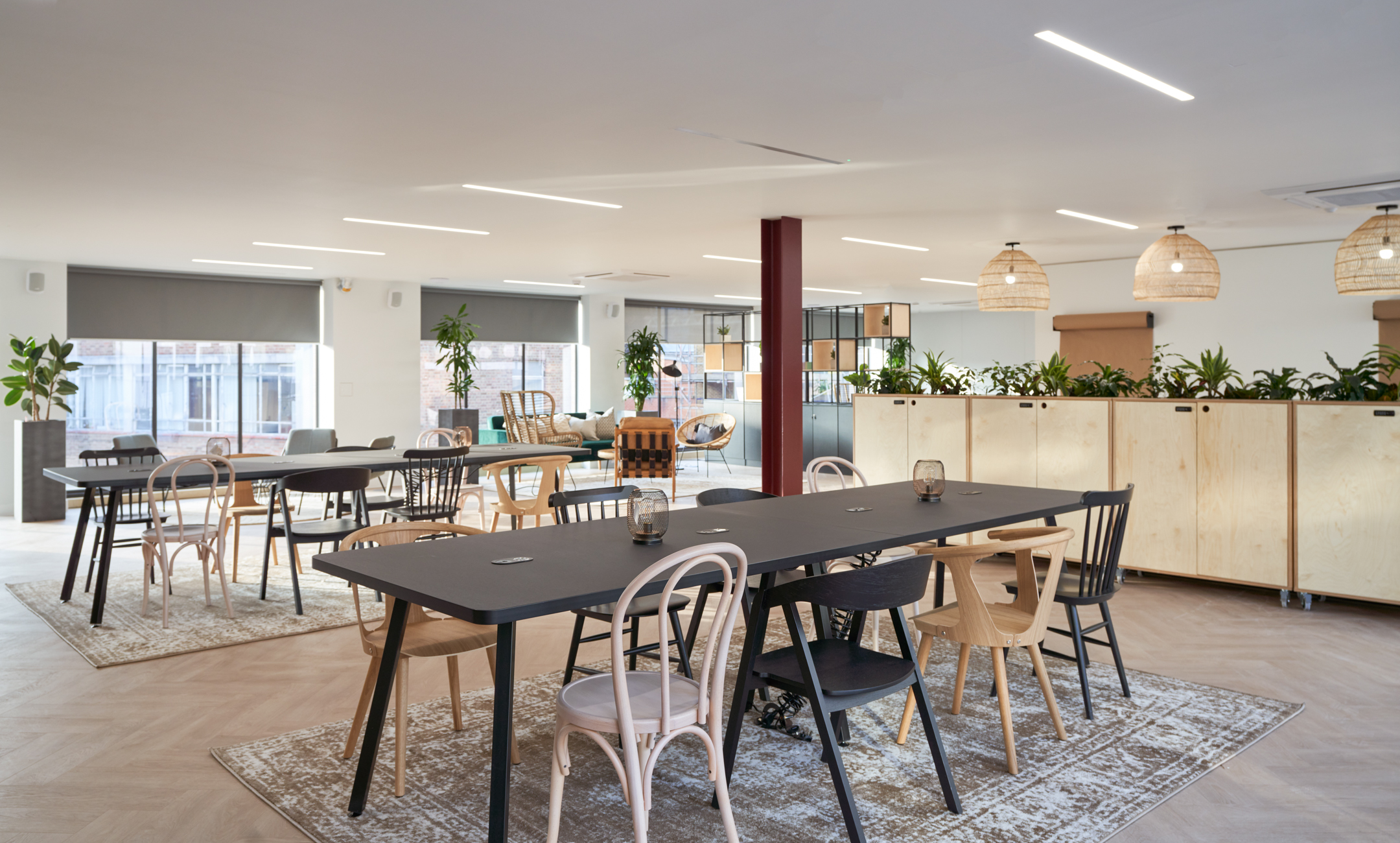 Eclectic dining and breakout area at Adyen with layered rugs, mixed seating styles and long communal tables, all sourced and installed with Platfform’s expertise.