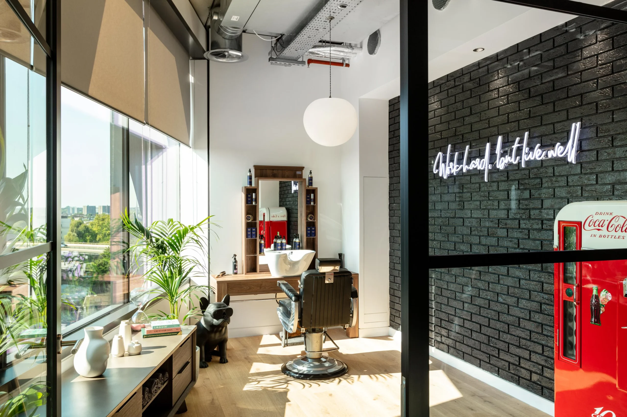 In-house barber shop at Alpha FX with vintage styling, retro fridge and curated furniture by Platfform, designed to bring character and convenience to the workplace.