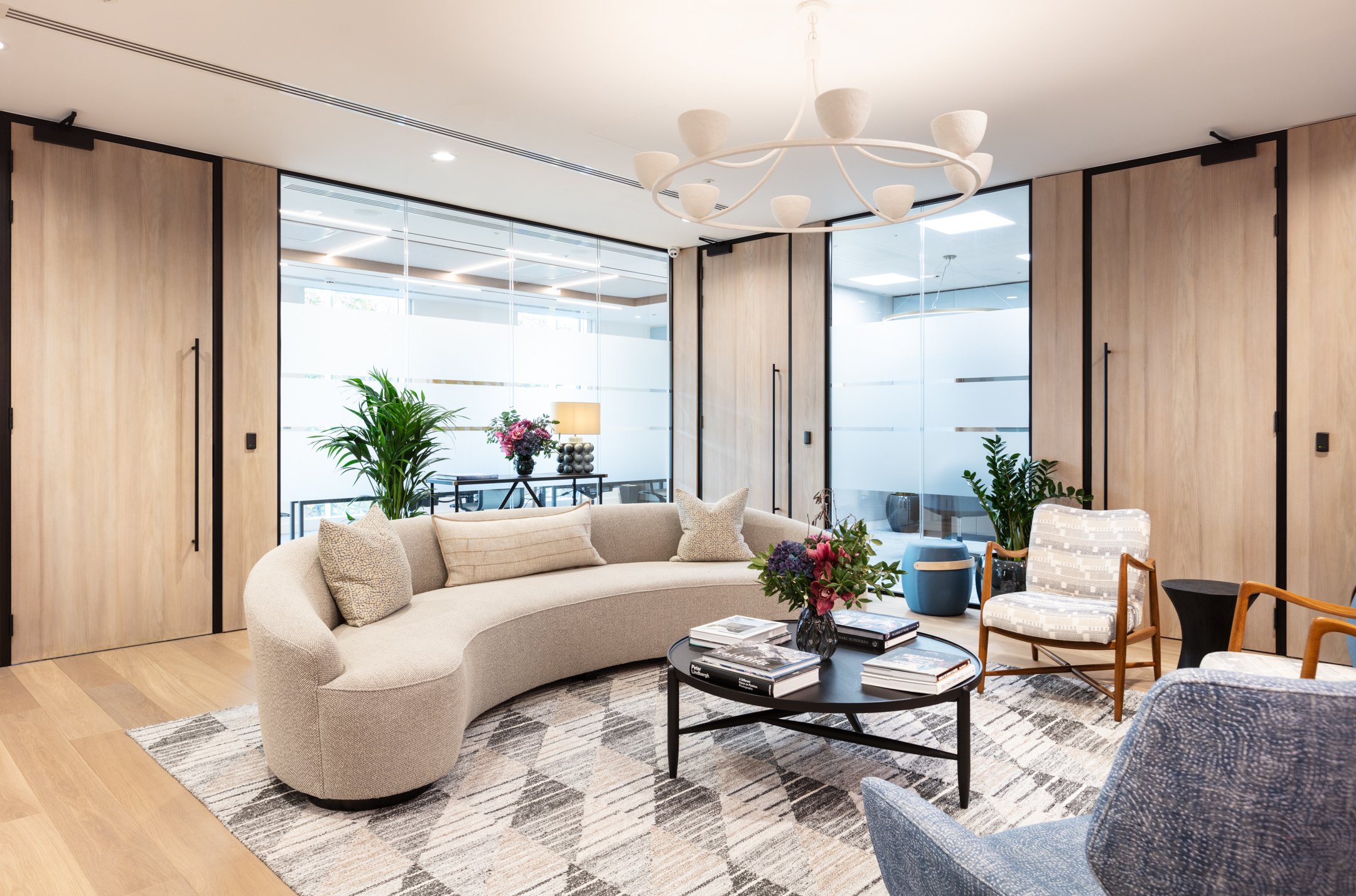 Reception space for an Asset Management Firm, styled by Platfform with soft neutral seating, patterned textiles, and timber-panelled doors.