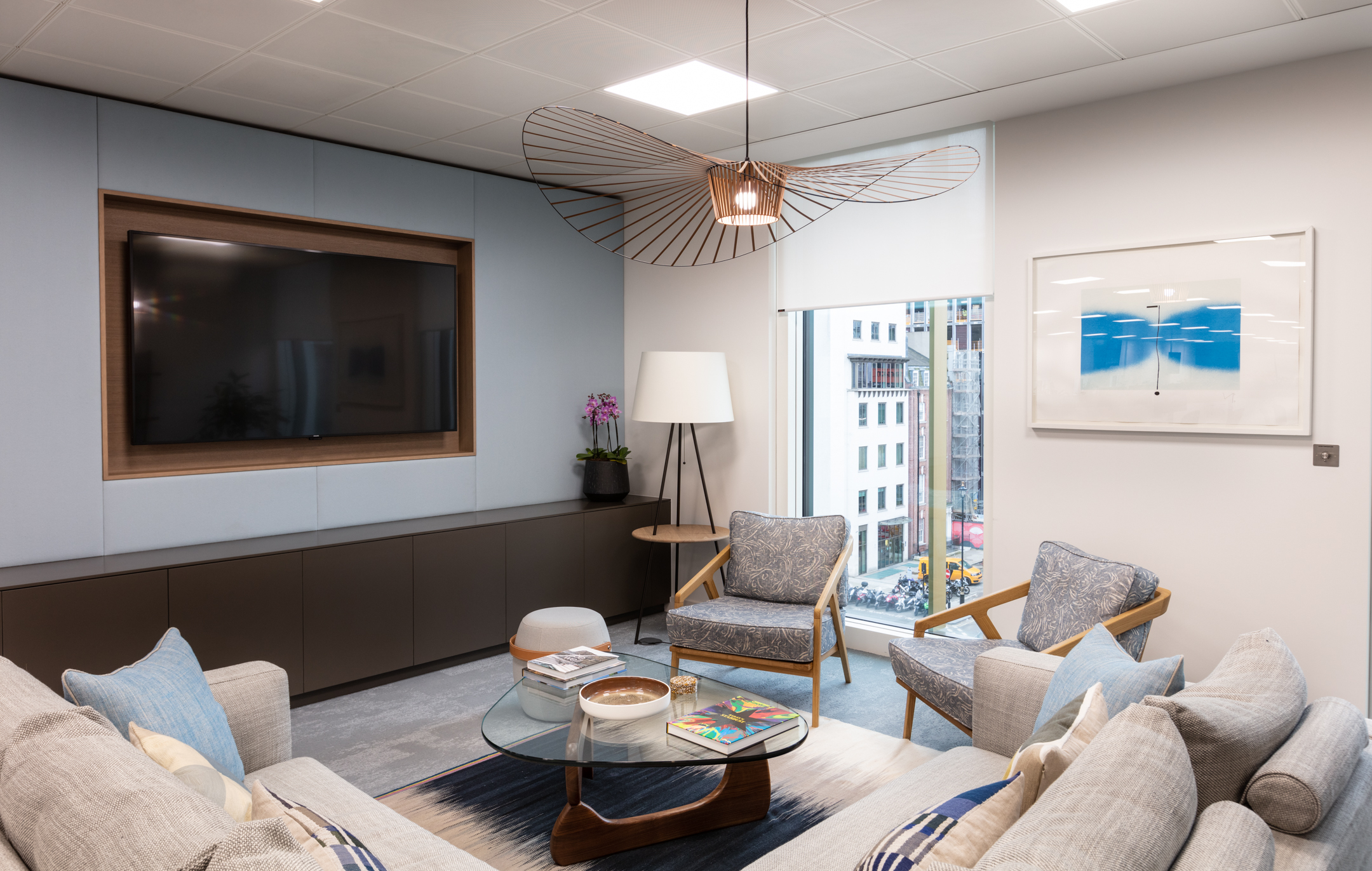 Lounge for an Asset Management Firm, furnished by Platfform with layered textiles, bespoke joinery, and city views through full-height glazing.