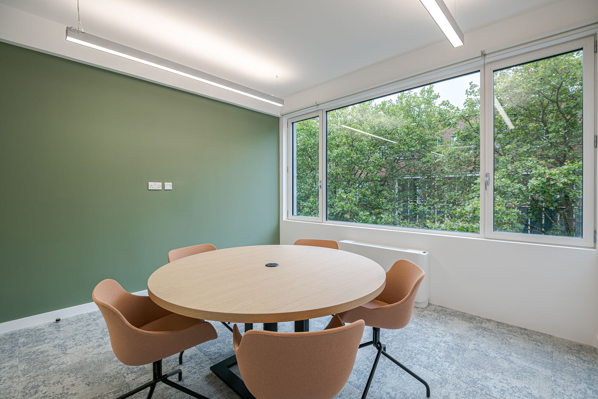 Elegant Berry Street office workspace designed by Platfform, featuring round meeting tables and vibrant plant decorations.