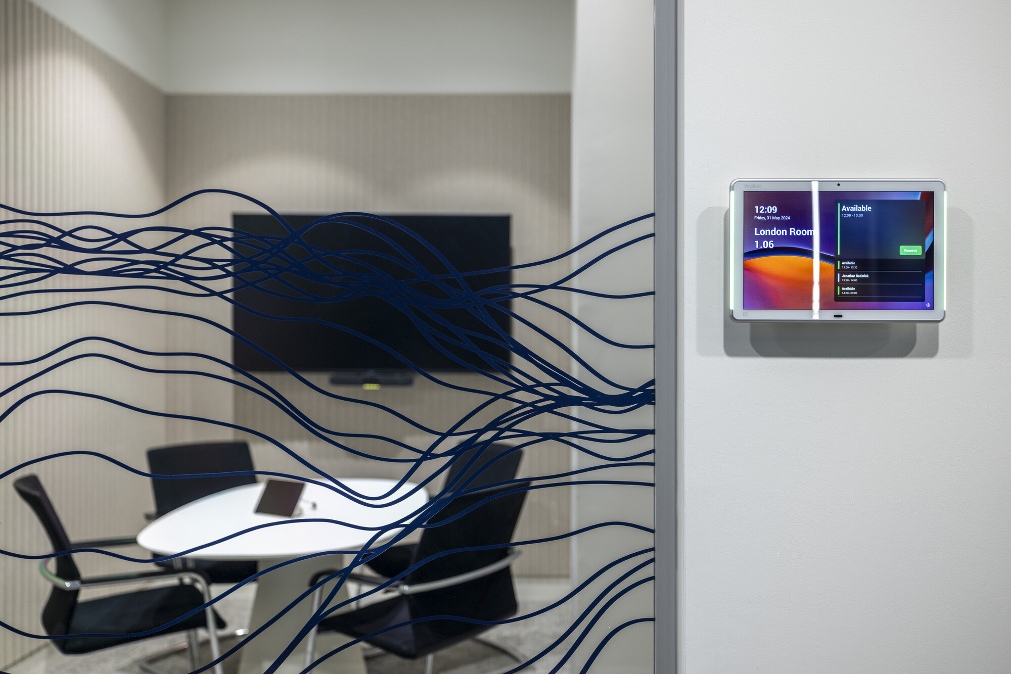 CMC Markets’ London HQ meeting room designed by Platfform, showcasing a digital room booking system and privacy-enhancing wave-patterned glazing