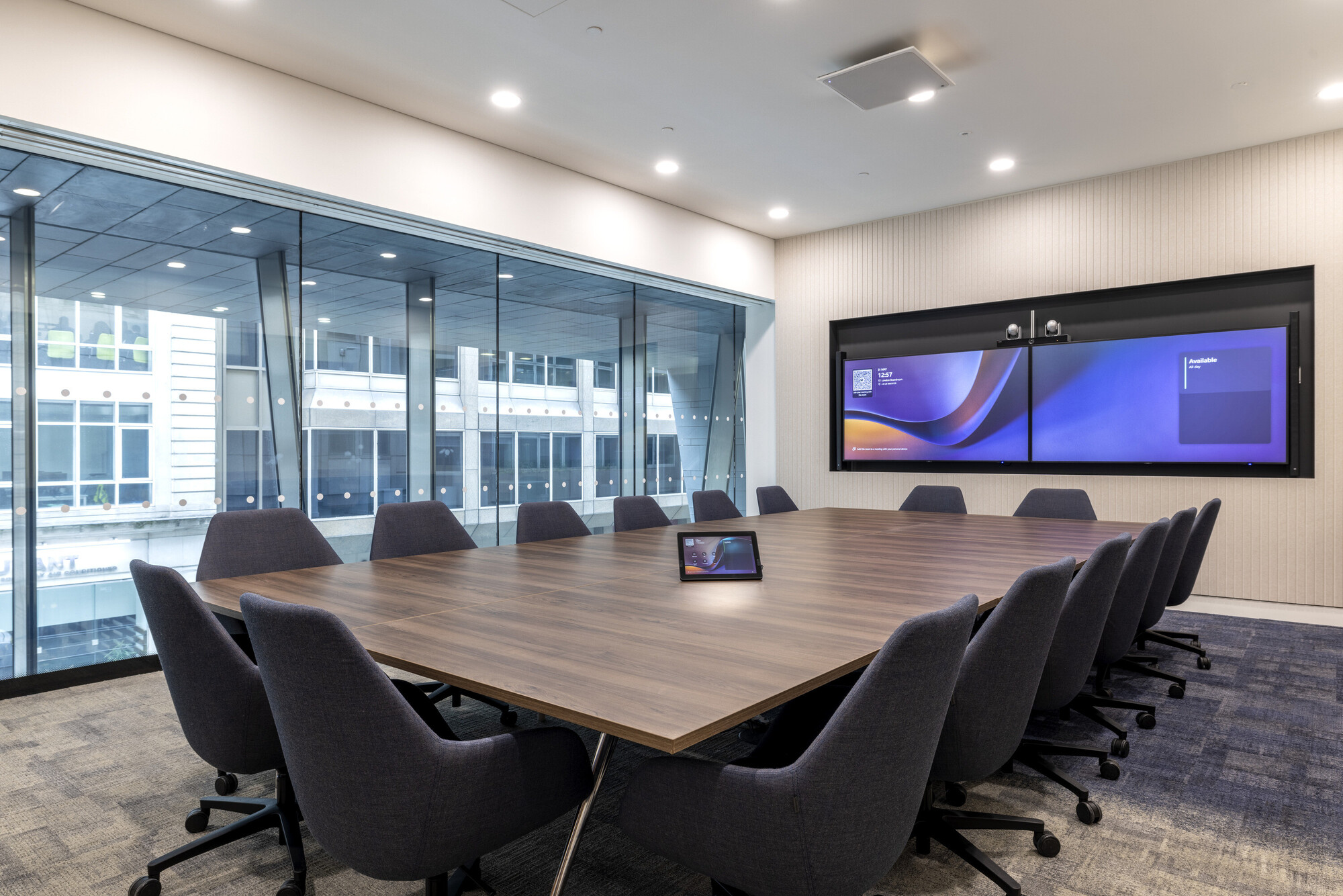 Executive boardroom at CMC Markets designed by Platfform, featuring advanced dual-screen technology and a sleek walnut conference table.