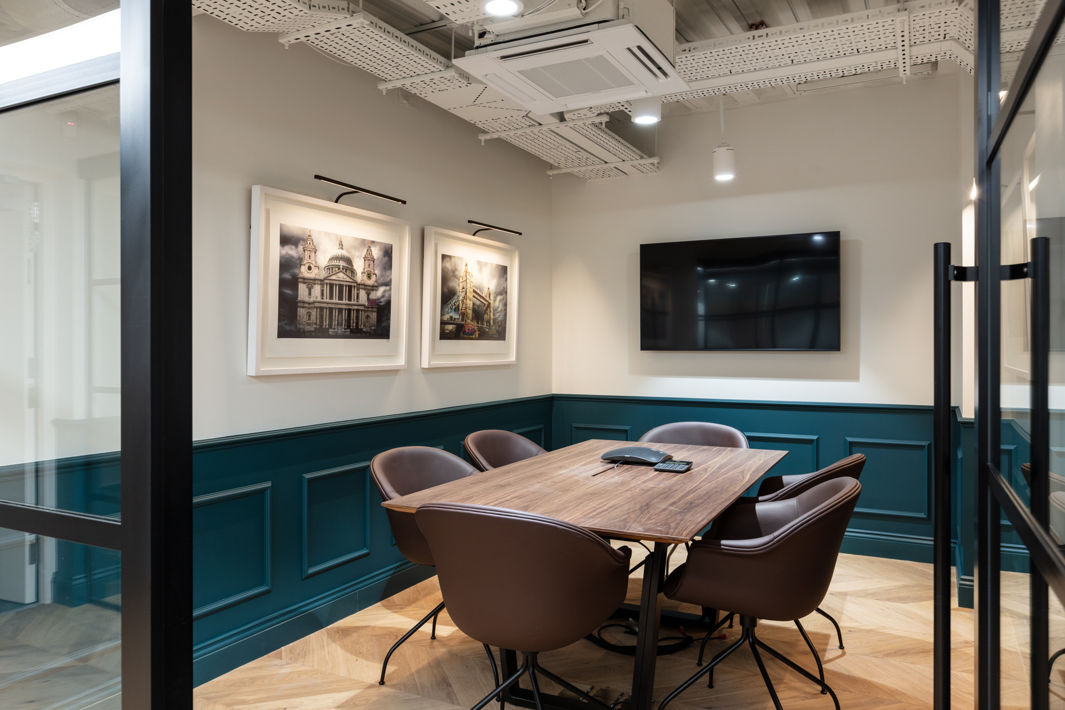 Intimate meeting room at Cain International with contemporary brown chairs and a walnut table, with all furniture curated by Platfform.