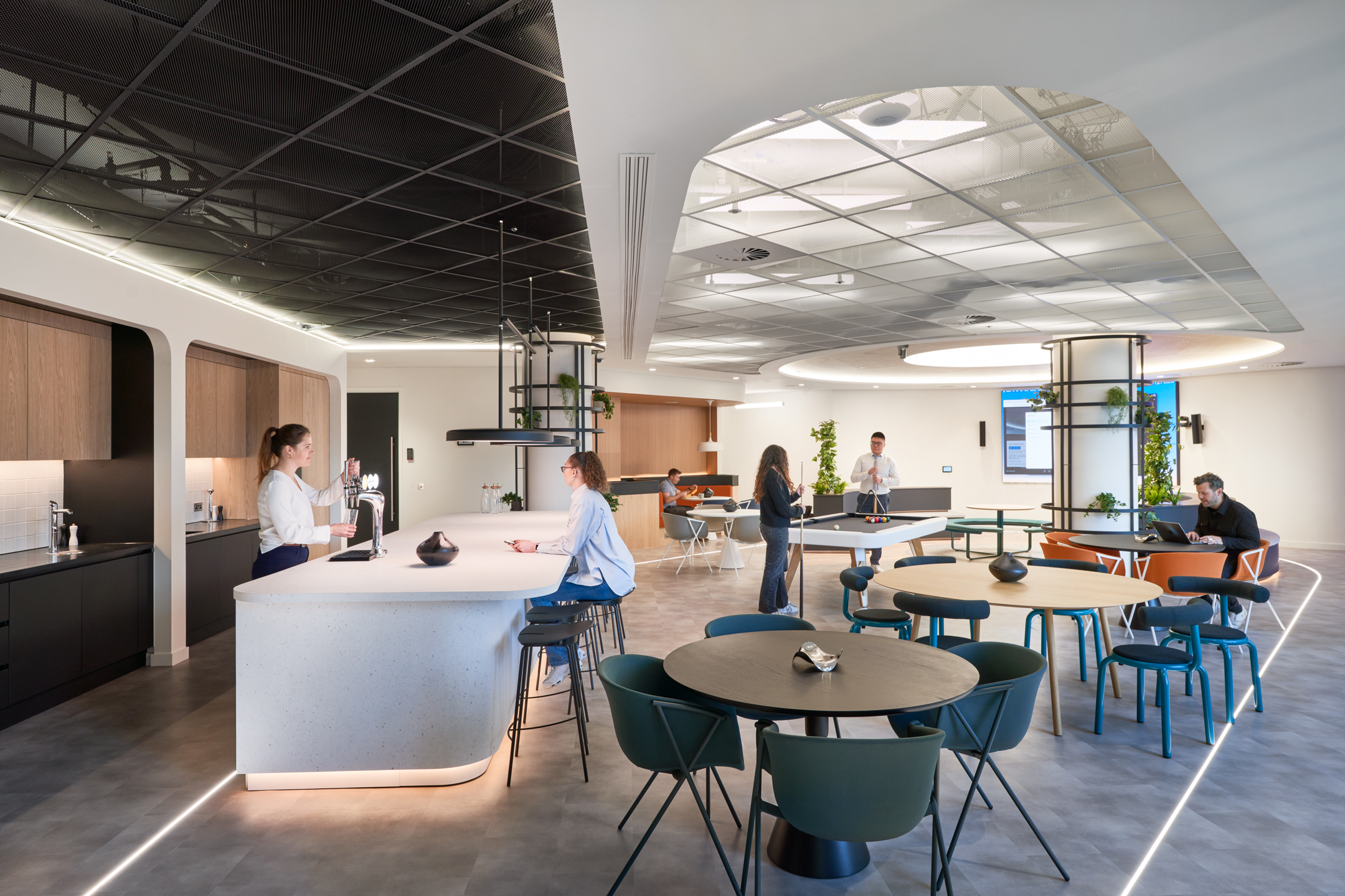 Social hub at capital.com featuring a kitchen island, bar stools, dining sets and breakout furniture curated and installed by Platfform.