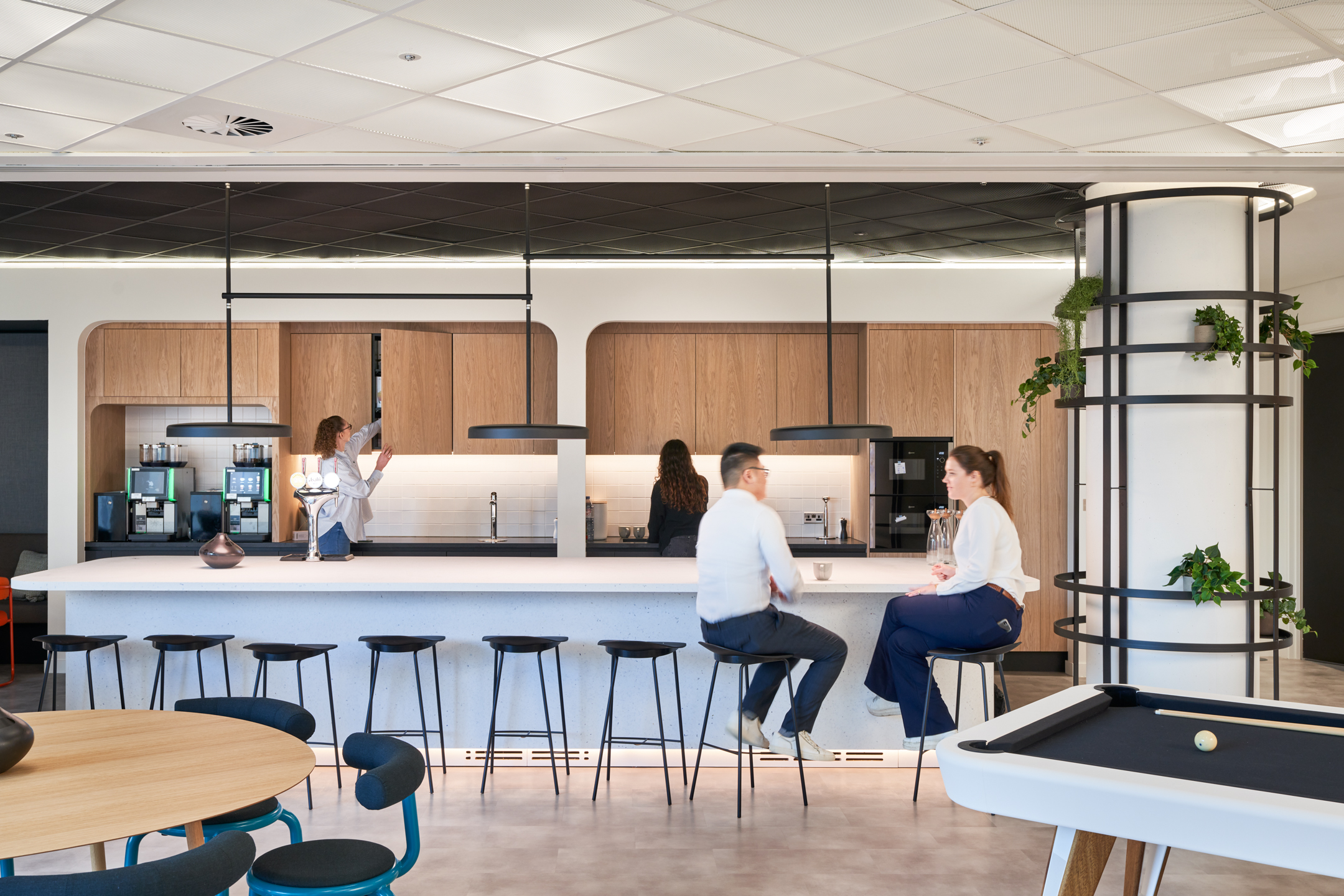 Capital.com kitchen and breakout zone with custom bar stools, round dining tables and a pool table setup delivered by Platfform.
