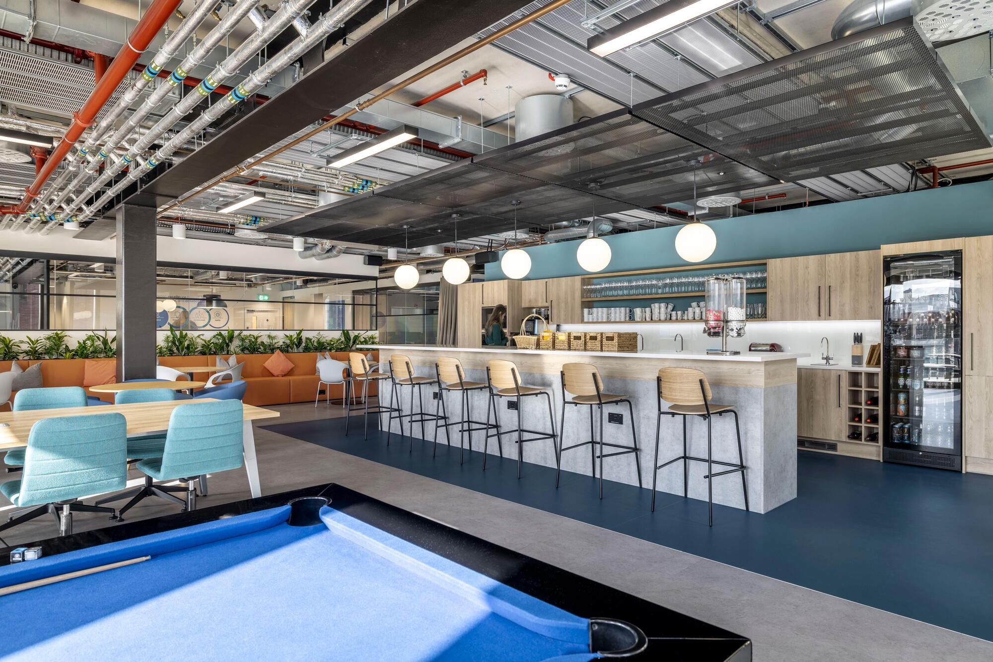 Teapoint and breakout space at Carbon Clean featuring soft seating, bar stools, and collaborative tables, with furniture supplied by Platfform.