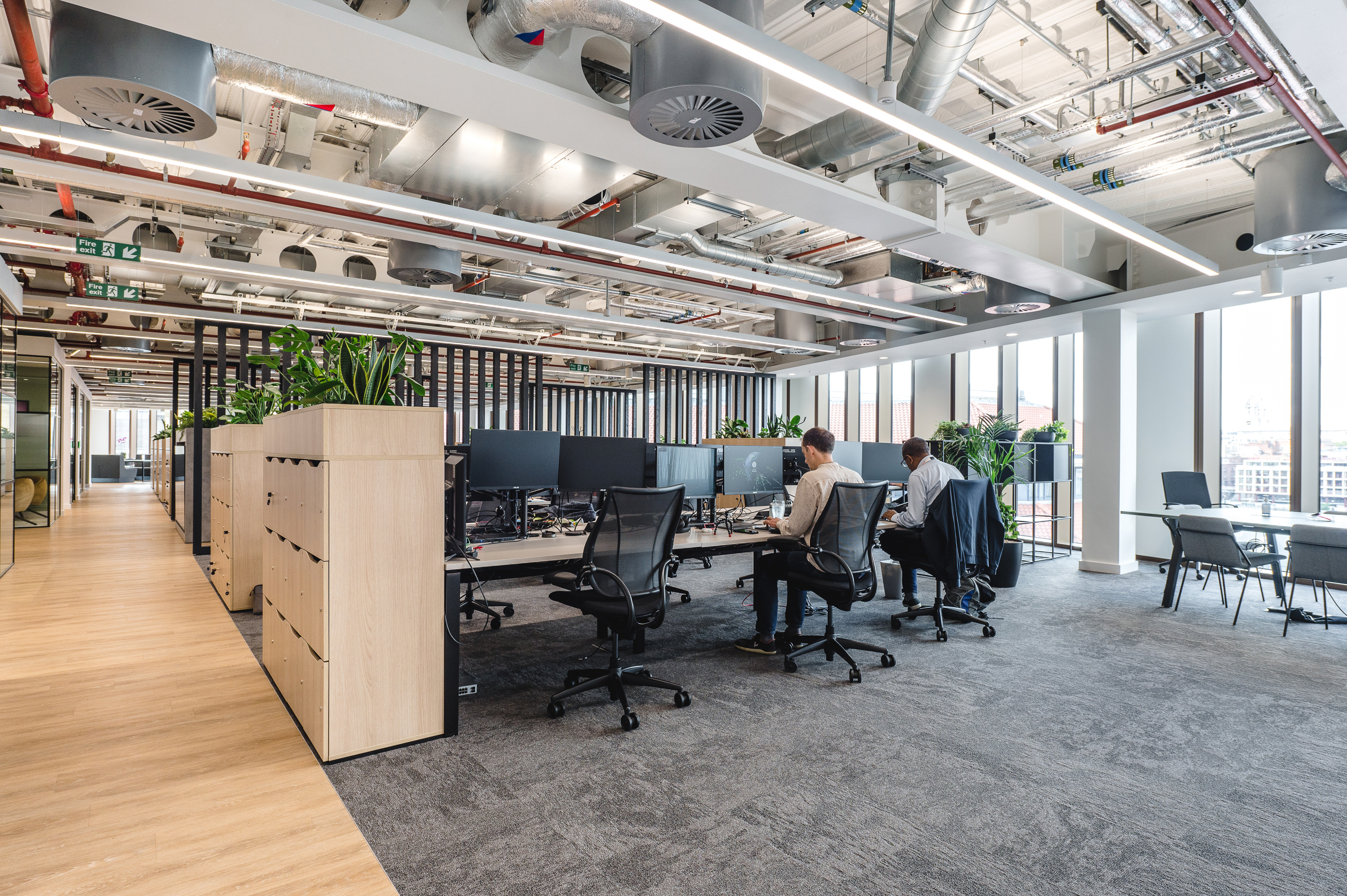 Open-plan workspace at Everyone TV with ergonomic task chairs, bench desking and planter-topped storage units, all sourced through by Platfform.