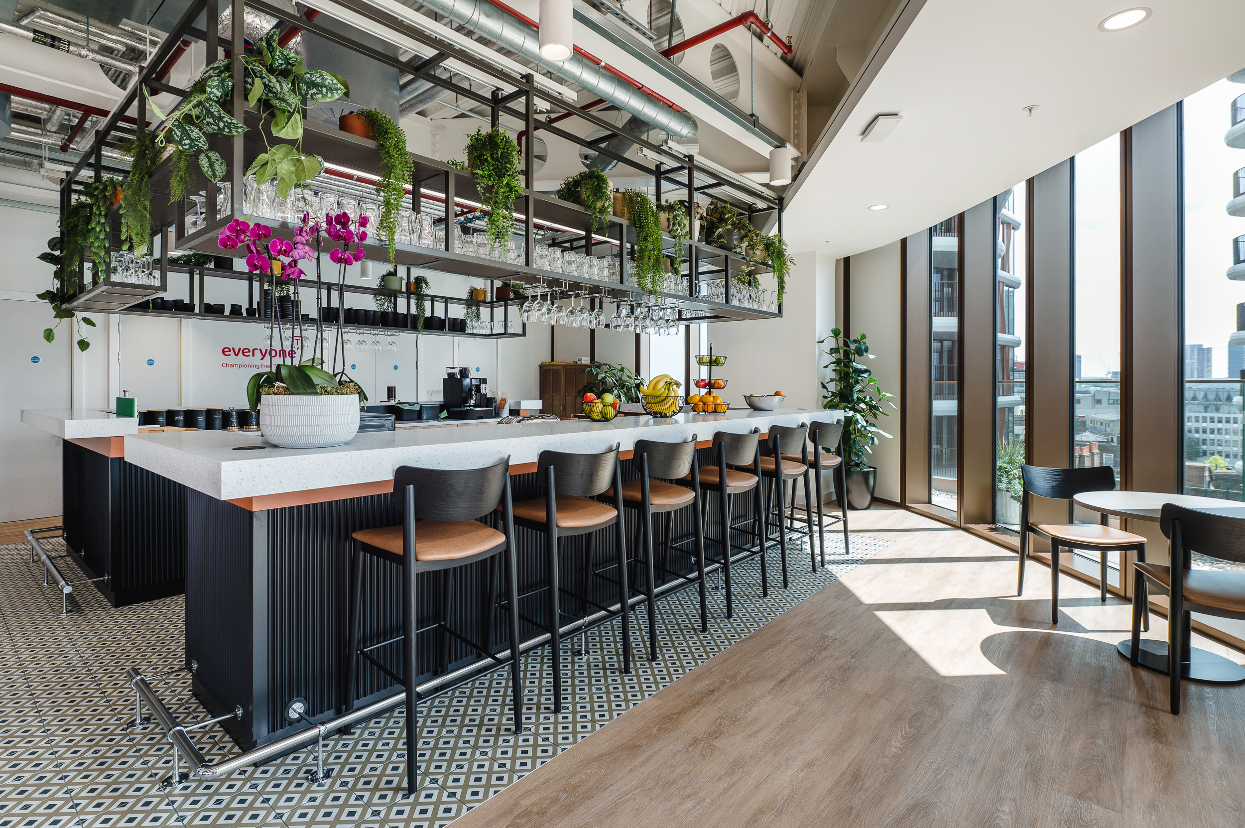 Teapoint and breakout space at Everyone TV, furnished with high stools and café-style seating.