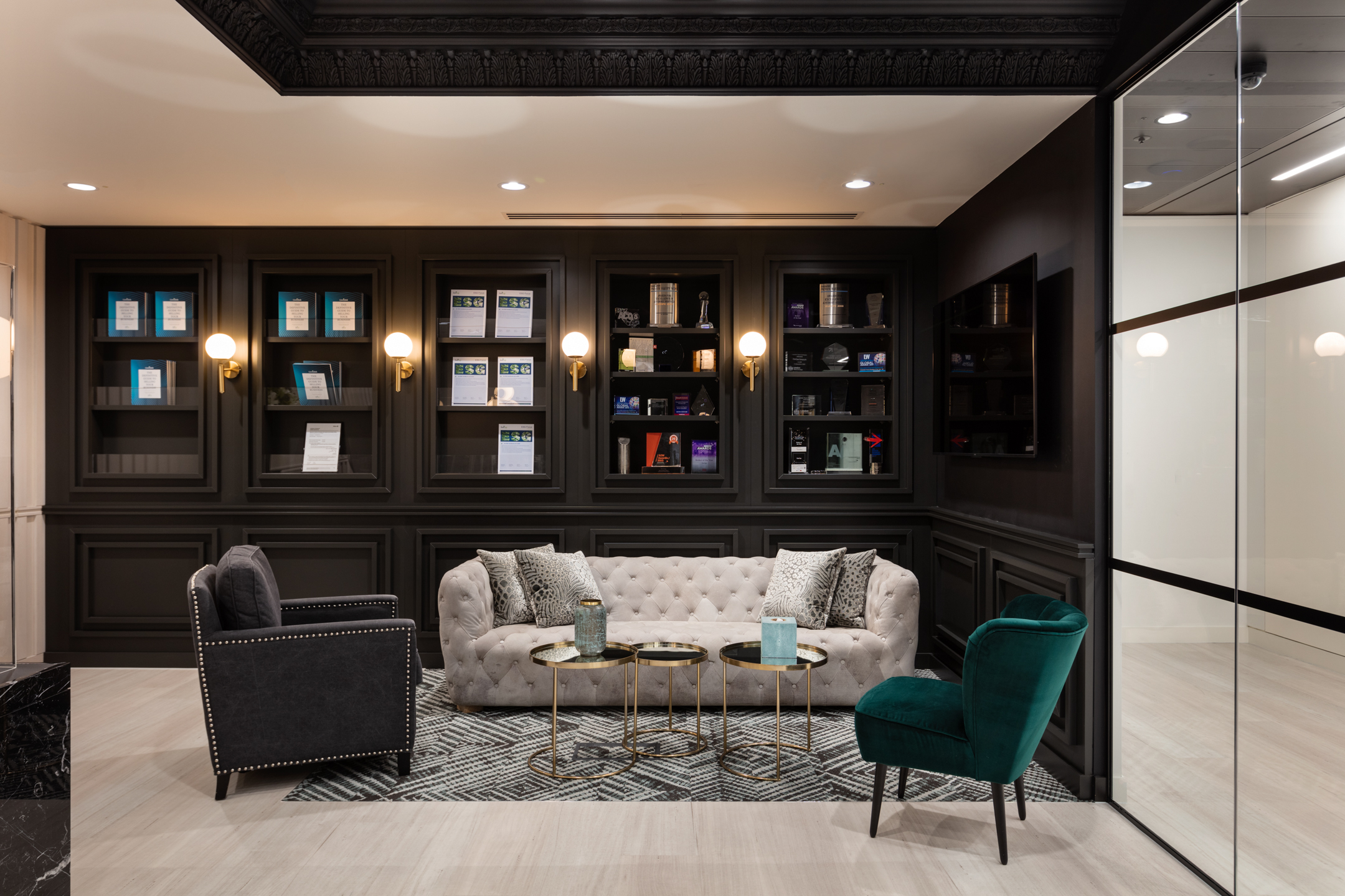 finnCap reception lounge with velvet seating and styled furniture, including a tufted sofa and gold-accented tables.
