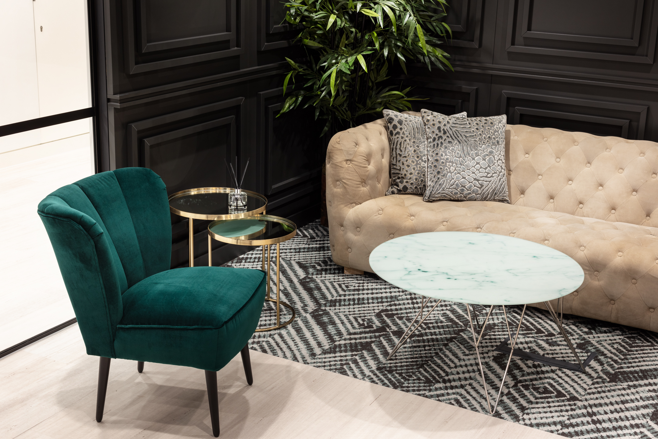 finnCap reception furniture by Platfform, including a velvet green chair, tufted sofa, marble coffee table and gold side tables styled on a monochrome rug.