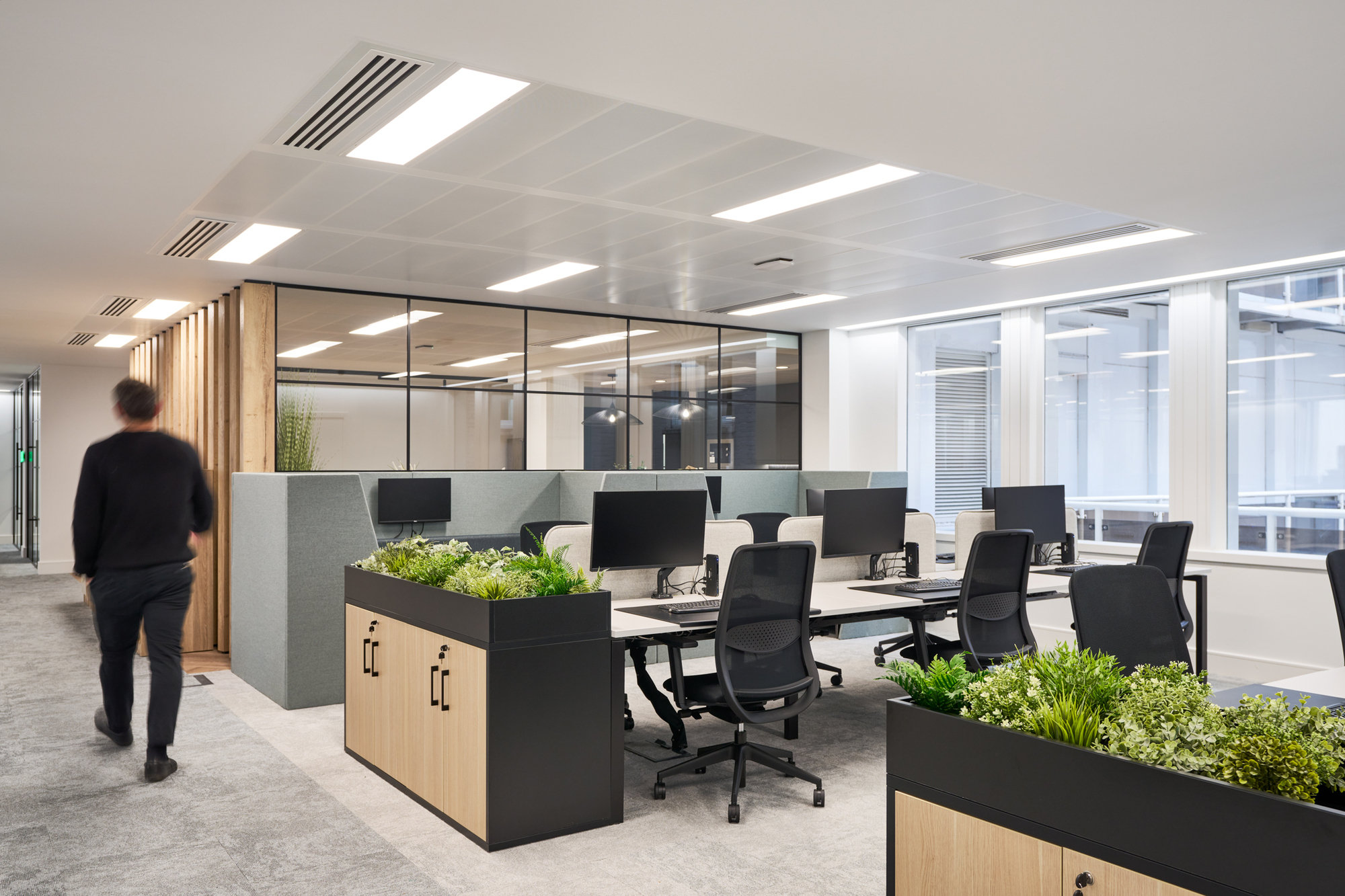 Gemserv's open-plan workspace designed by Platfform, featuring ergonomic desks, acoustic dividers, and greenery for a balanced and productive environment.