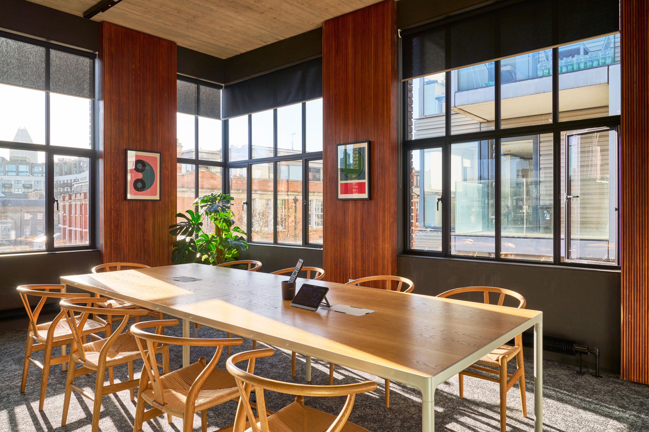 Meeting room in the Joseph Joseph office, furniture by Platfform, showcasing a large wooden table, natural light, and views of the surrounding cityscape.