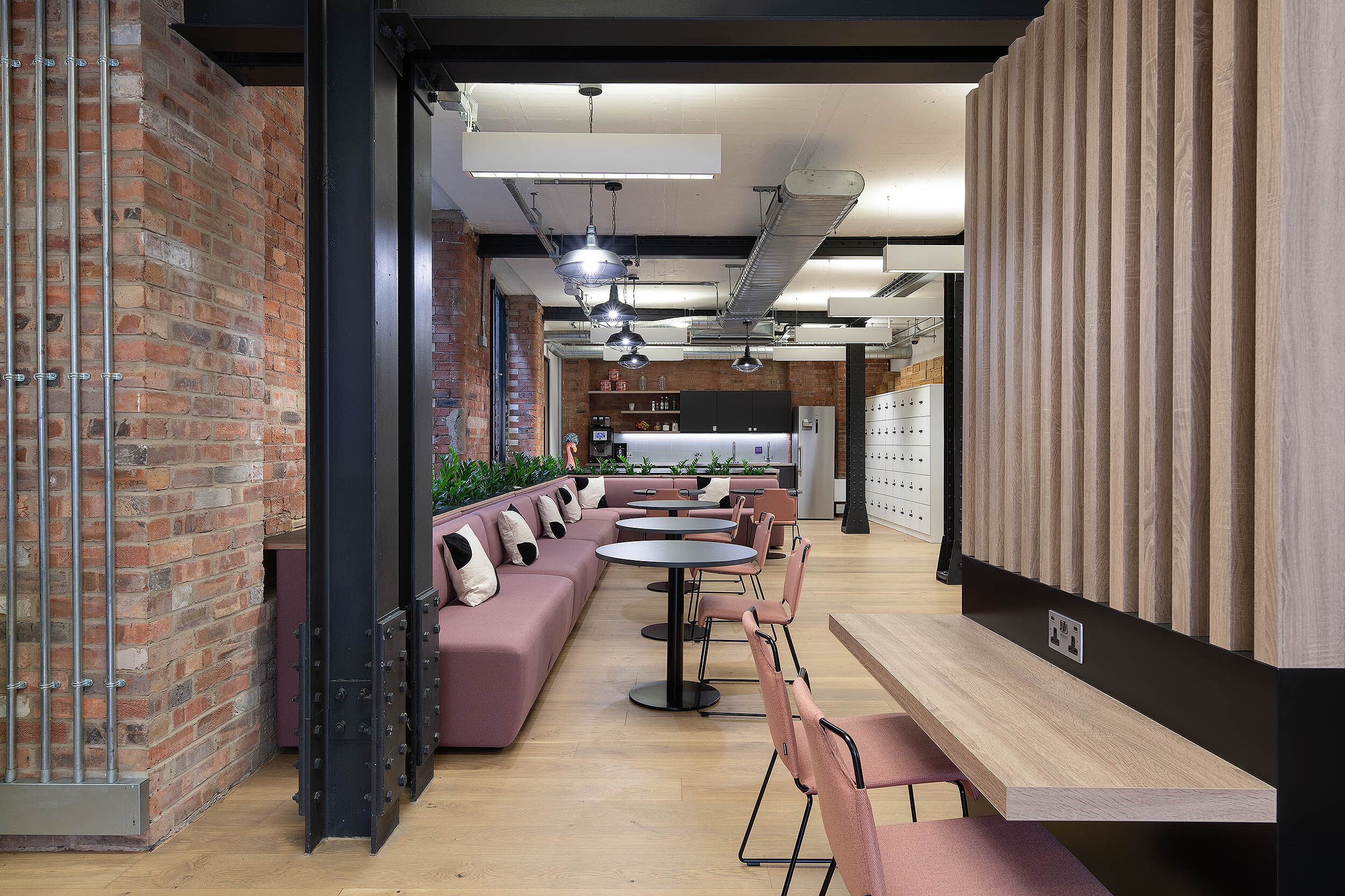 Collaborative workspace designed by Platfform, showcasing stylish seating, exposed brick interiors, and a communal workstation.