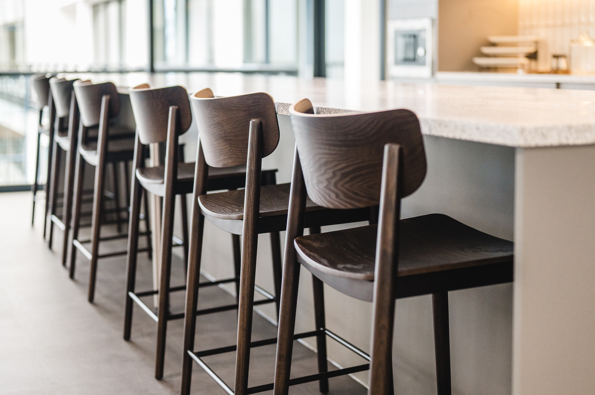 Close-up of the dark wooden bar stools at the Serendipity Labs Bristol teapoint.