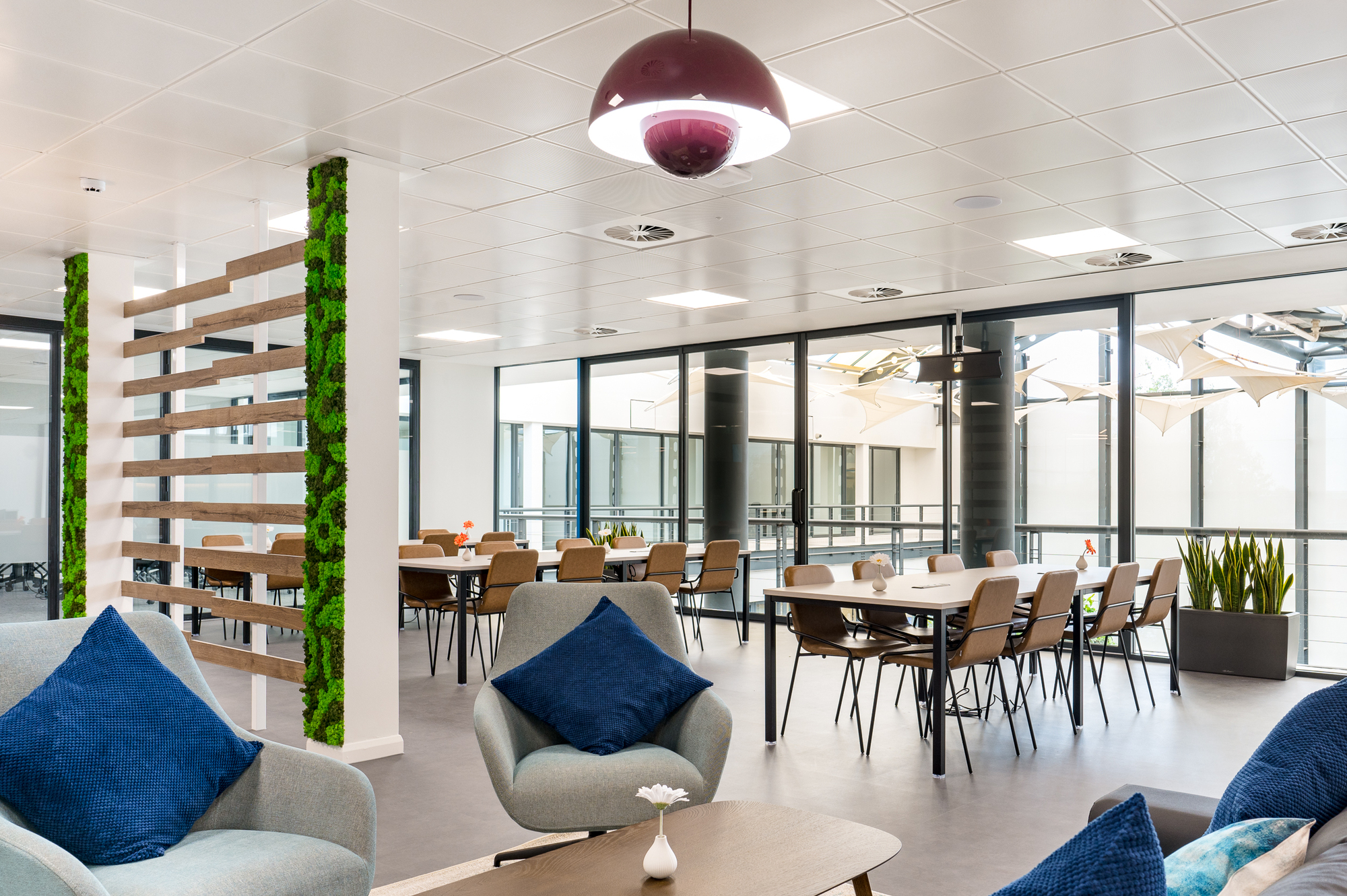 Lounge seating and dining area separated by a wooden feature with greenery, designed by Platfform for Serendipity Labs in Bristol.