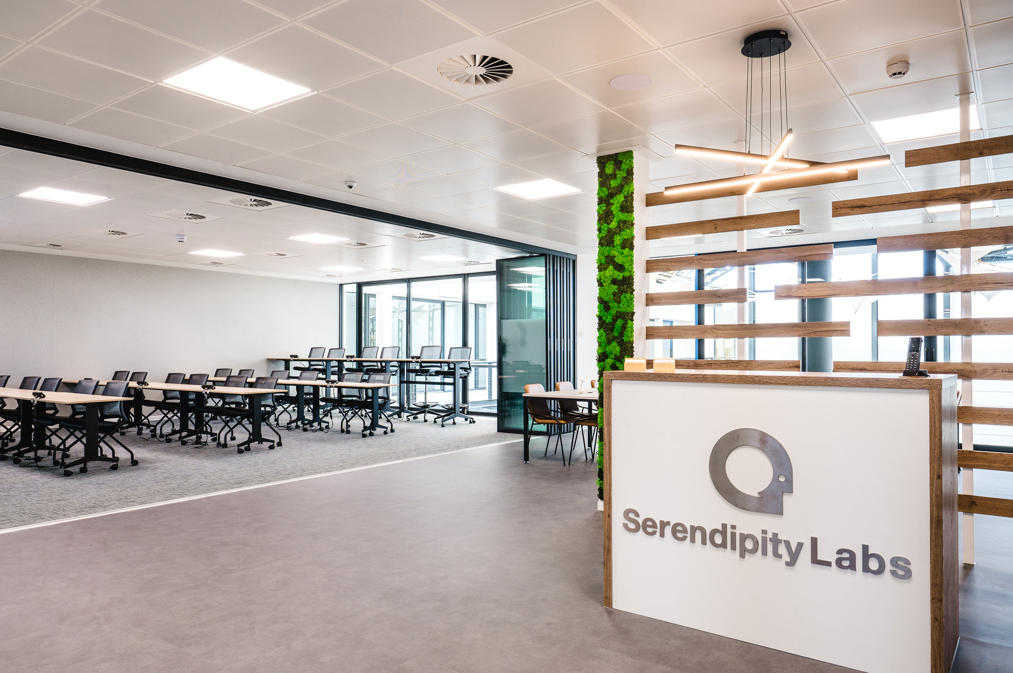 Serendipity Labs reception area with a folding wall opening into the adjacent training room, showcasing versatile workspace design.