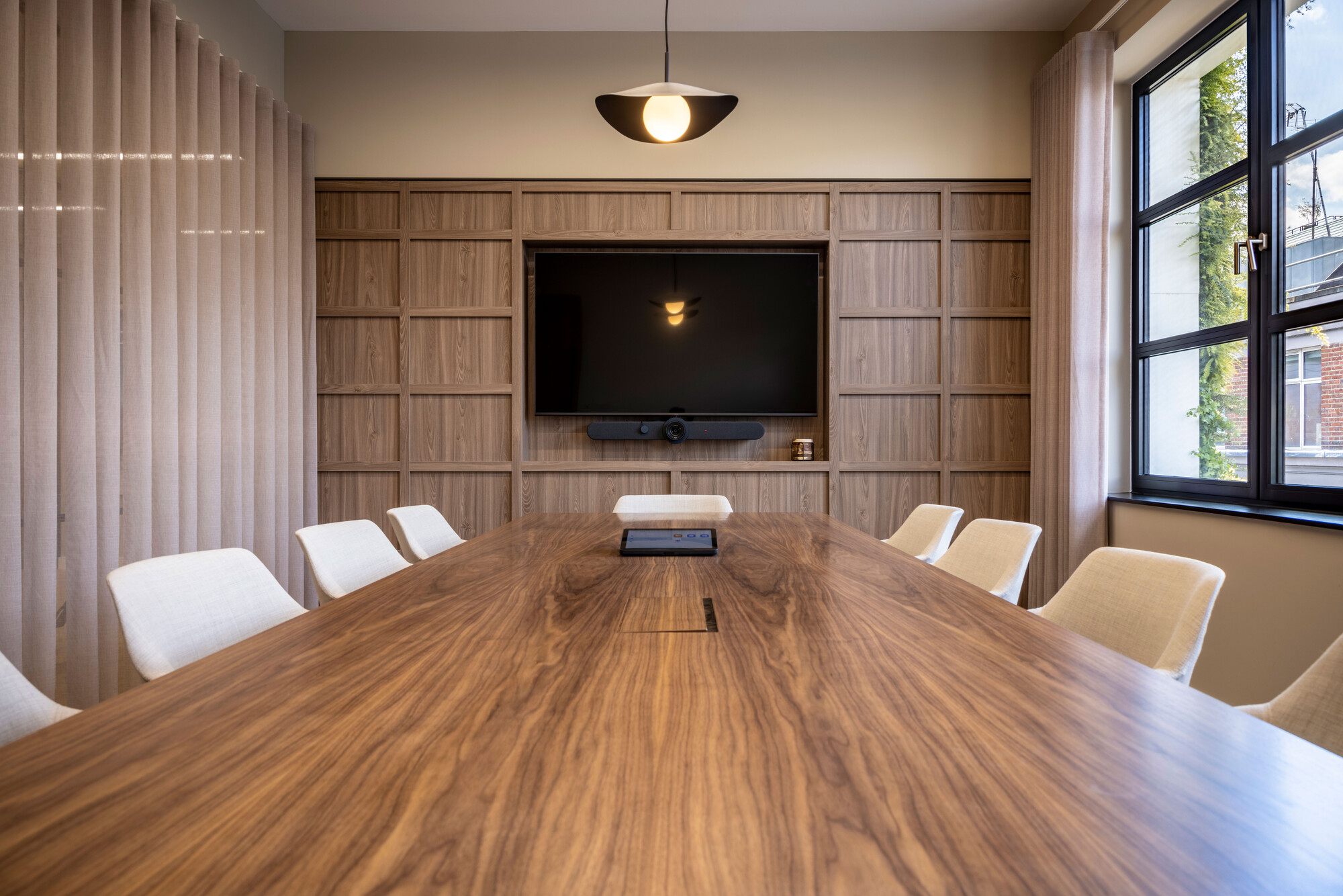 Transition's meeting space with a timber table and integrated AV wall, designed by Platfform to reflect sustainability and elegance.