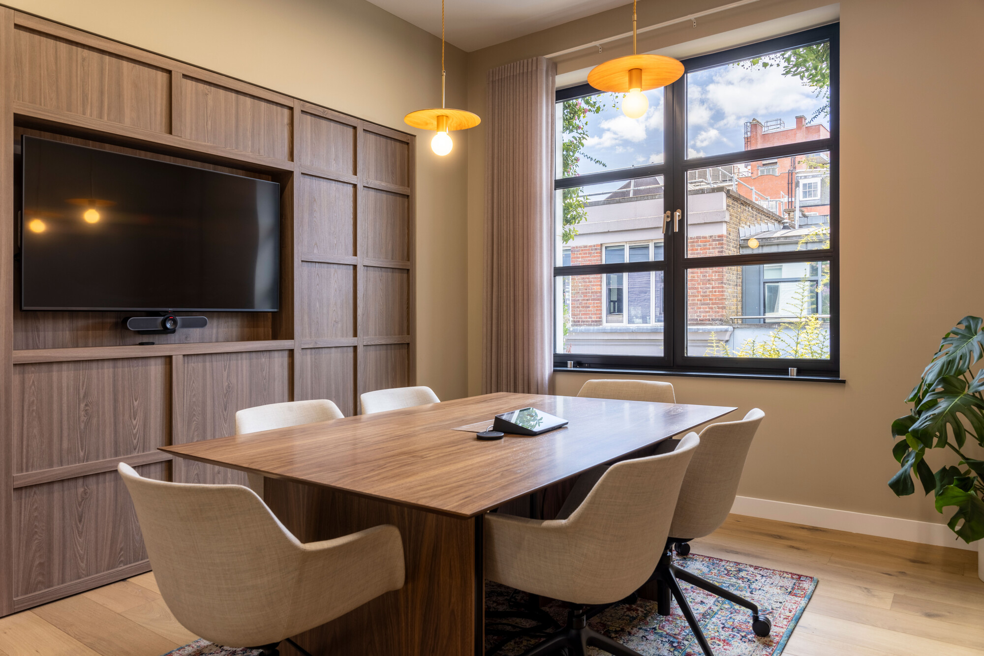 Transition's meeting room designed by Platfform, featuring a wood-panelled wall and a large window for natural light.
