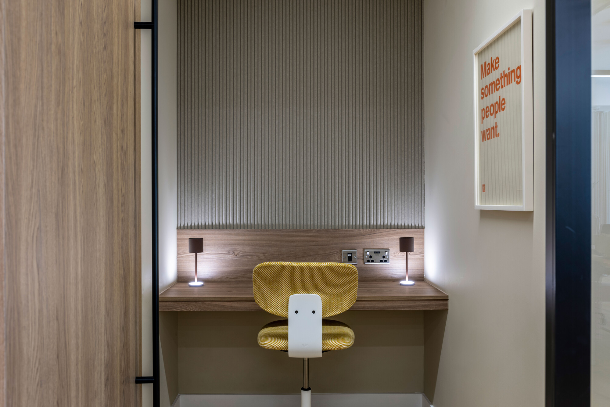 The zoom room at Transition has a wooden desk and a yellow chair for a functional yet stylish setup