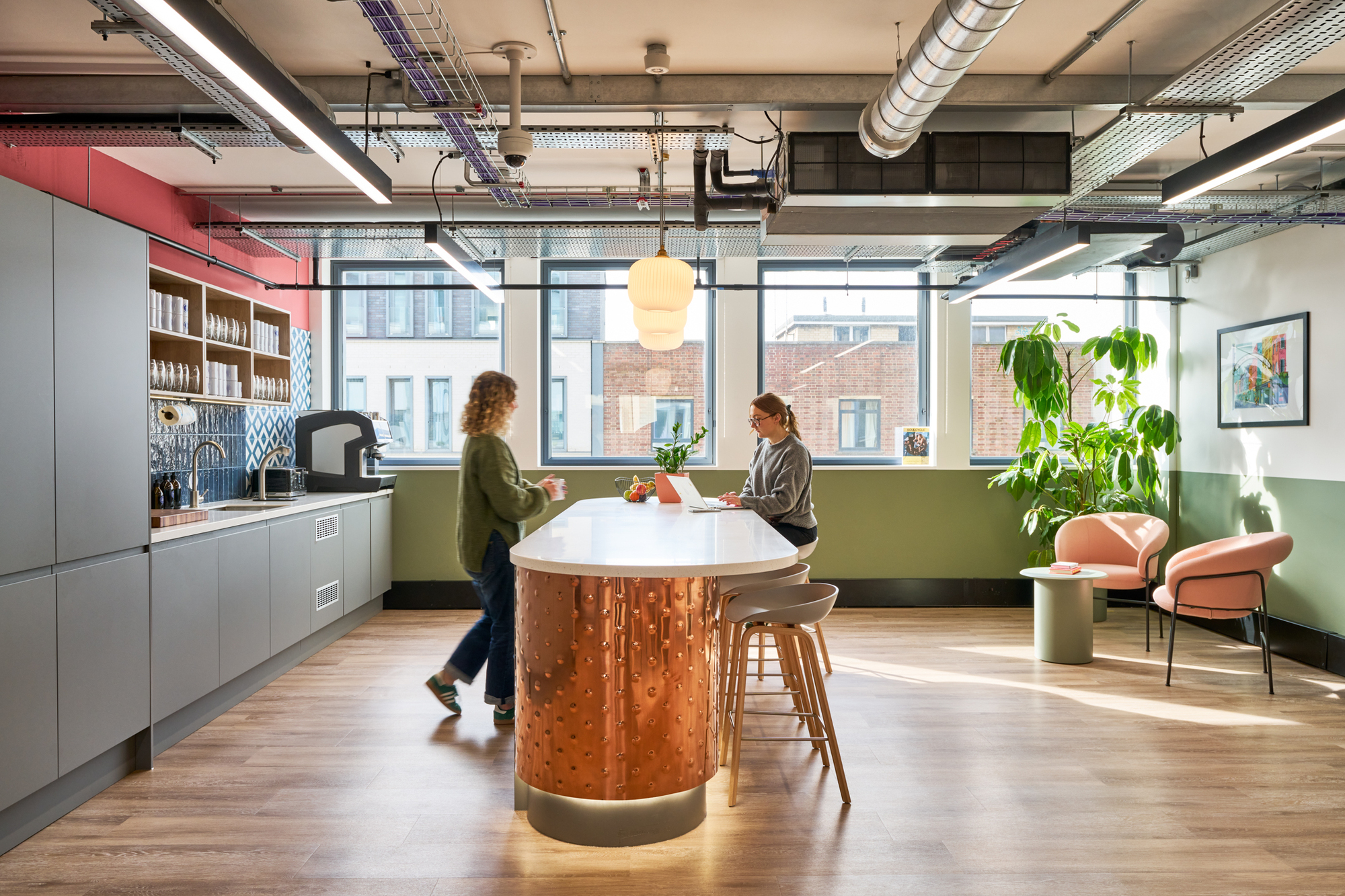 The teapoint at Work.Life Waverly House, designed by Platfform, with a copper island unit and bold green accents, blending style and functionality.
