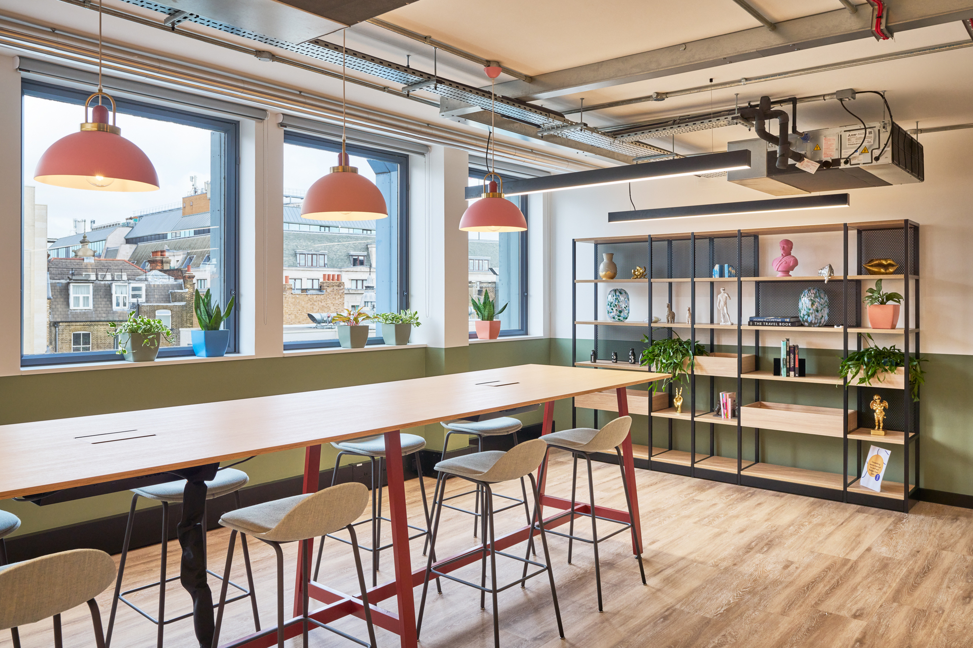 Collaborative workspace at Work.Life Waverly House, designed by Platfform, with a long table, colourful pendant lights, and shelving for a dynamic setting