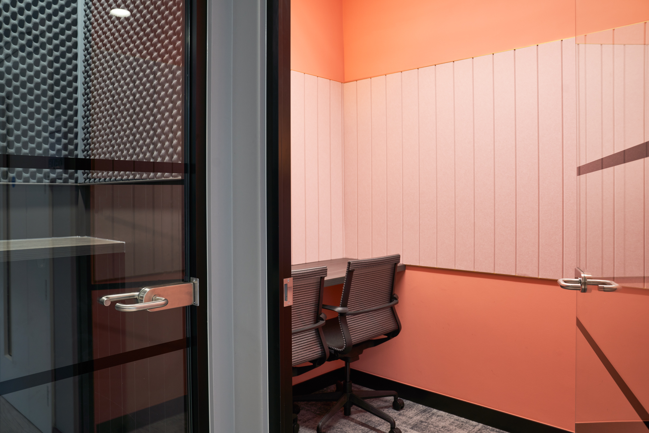 A cosy phone booth at Work.life Rivington House, with soundproofed walls and a bright orange design, providing a private workspace option by Platfform.