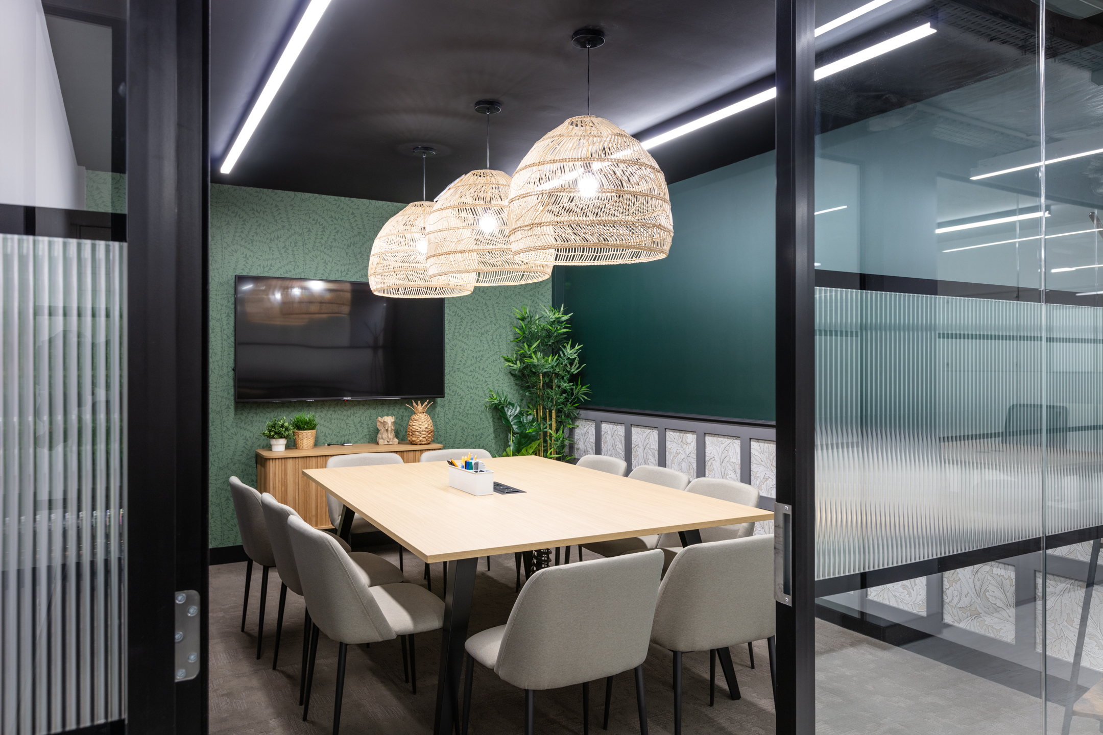 A private meeting room at Work.life Red Lion Street, with wicker lighting, a green accent wall, and thoughtful design elements by Platfform for seamless workspace functionality.