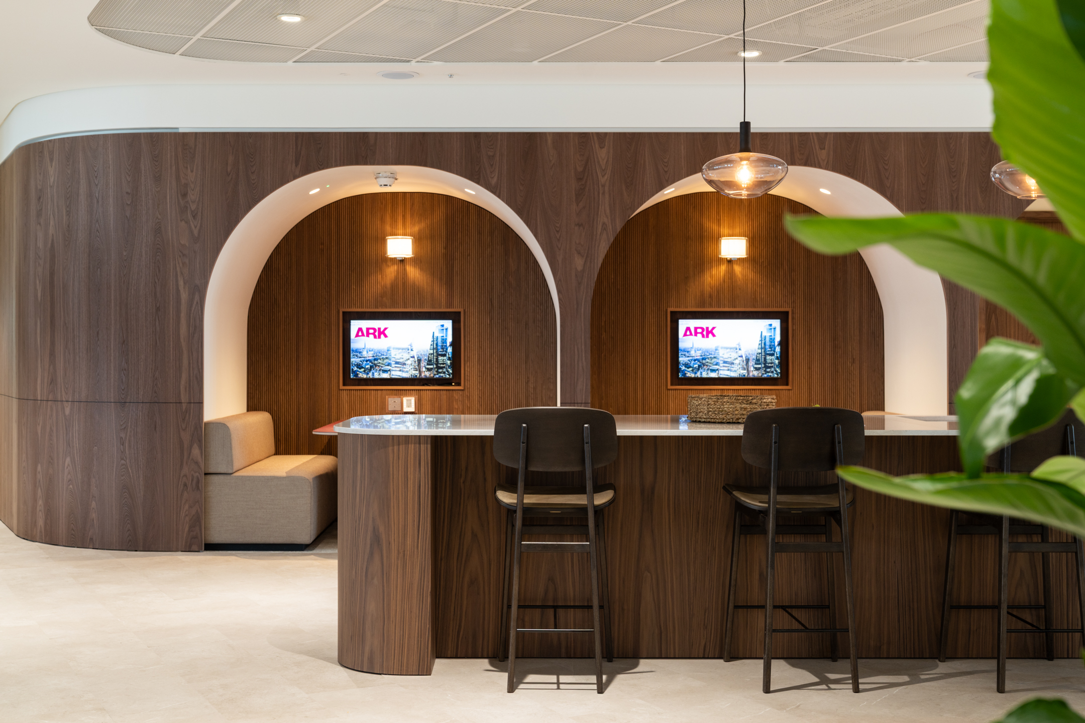Ark Syndicate breakout bar with arched timber booths and integrated screens designed for impromptu meetings and solo focus.
