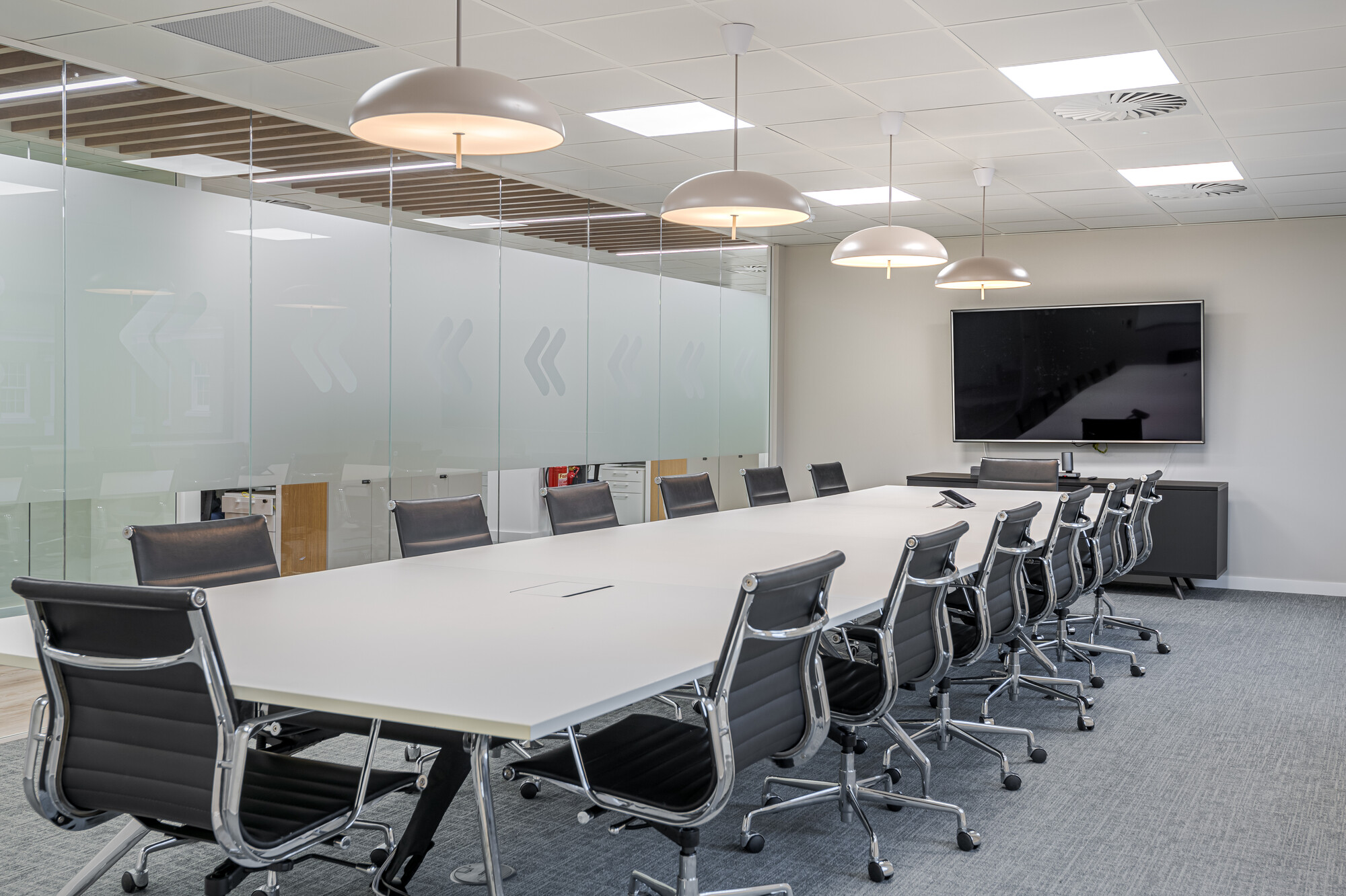 Accelya’s meeting room with sleek black chairs, clean-lined table and soft pendant lighting, furnished by Platfform for a refined boardroom feel.
