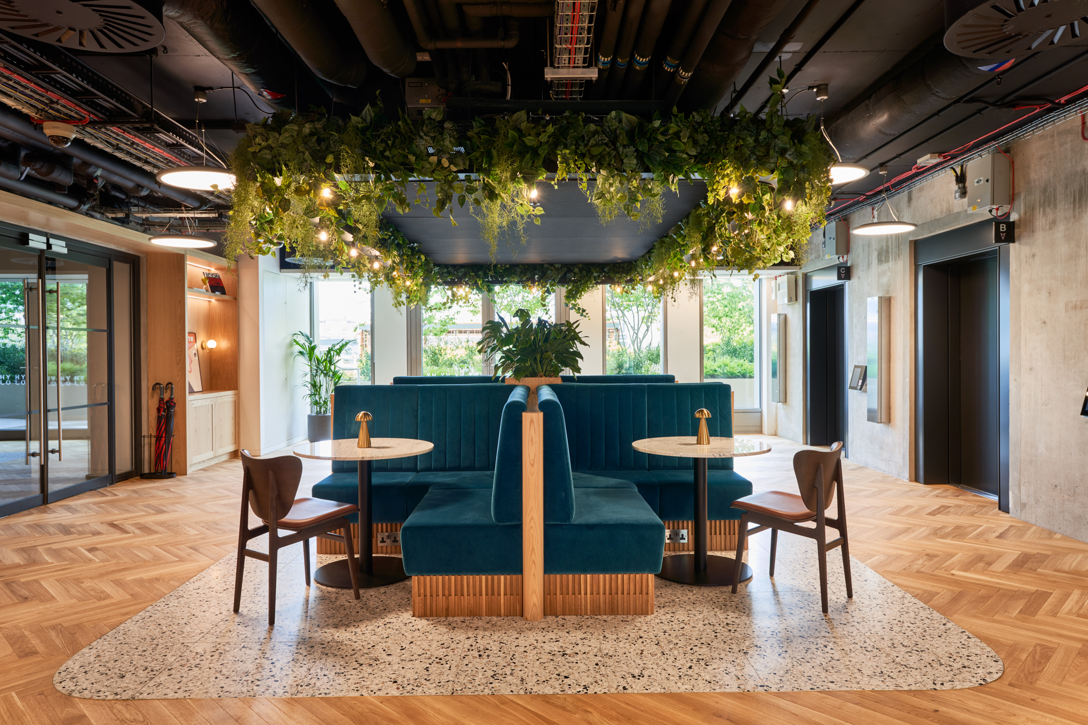 Bespoke banquette seating with teal upholstery and terrazzo-topped tables at HYLO, with furniture specified and supplied by Platfform.