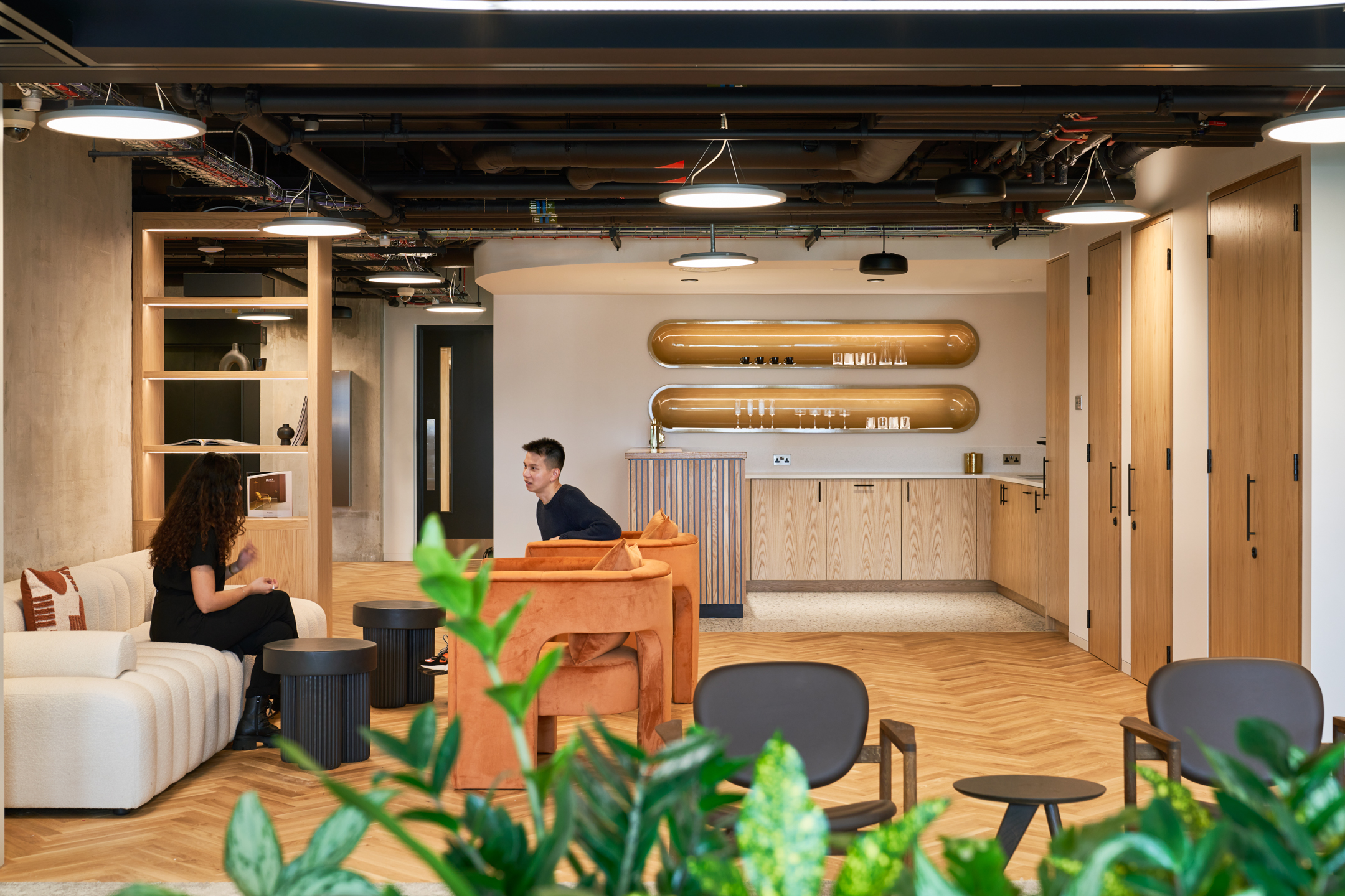Warm-toned lounge at HYLO with rust velvet armchairs, boucle sofa and timber joinery, featuring furniture sourced by Platfform.
