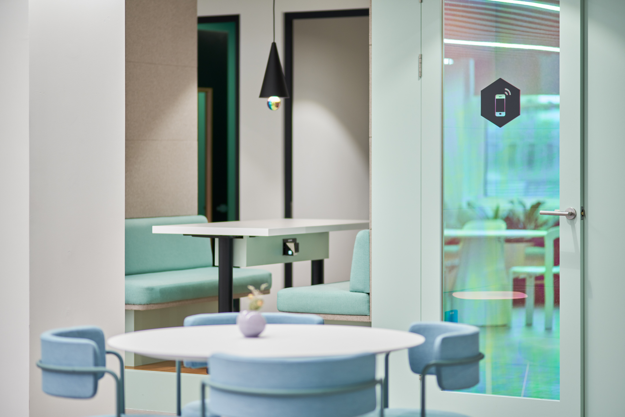 Close-up of mint-toned booths and soft blue meeting chairs at Huckletree Oxford Street, part of the furniture package delivered by Platfform.