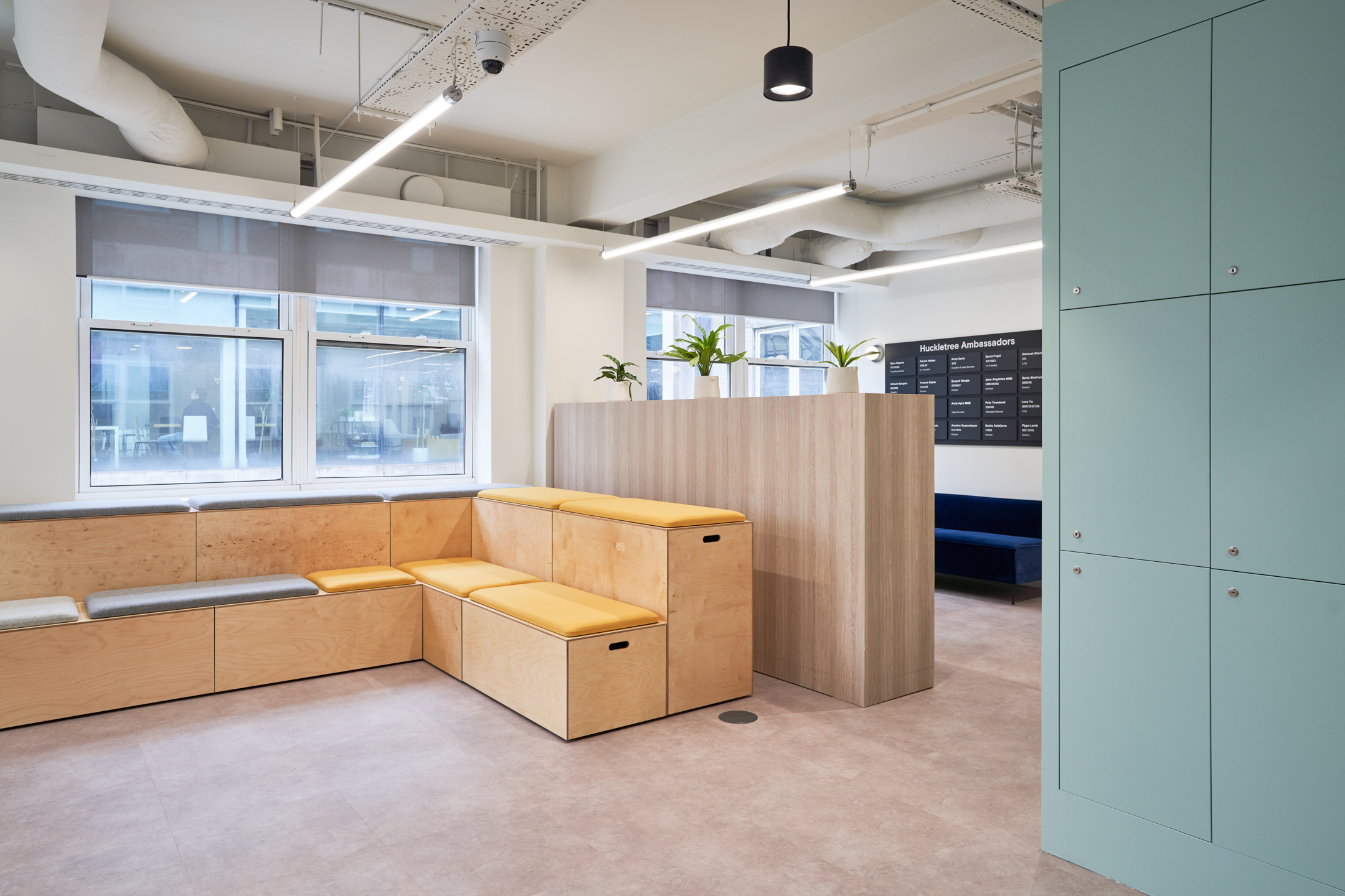 Tiered timber seating with yellow cushions at Huckletree Oxford Street, designed for casual meetings and furnished by Platfform.