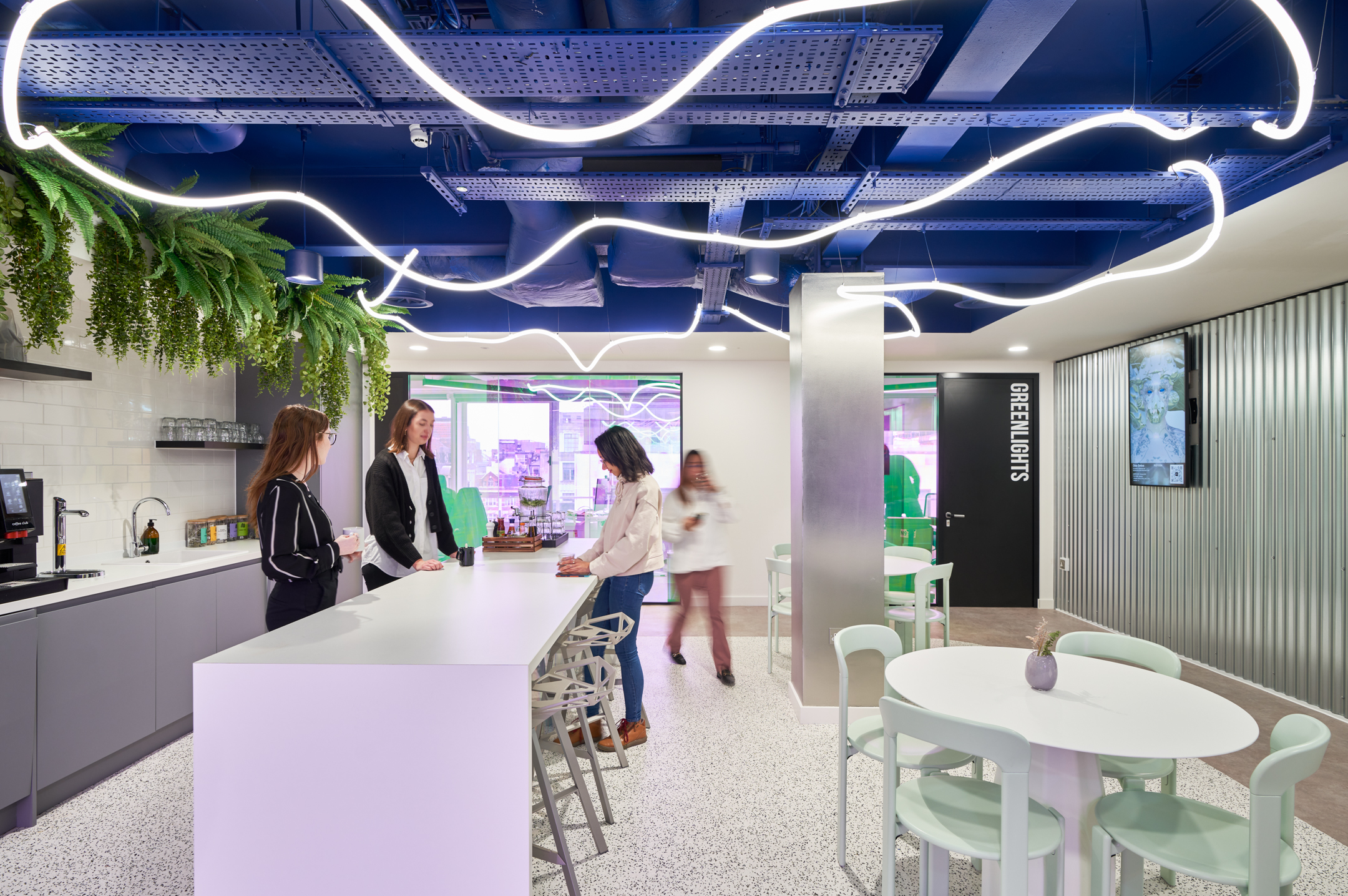 Bright breakout space at Huckletree Oxford Street featuring mint green dining chairs, sculptural bar stools and overhead strip lighting, furnished by Platfform.