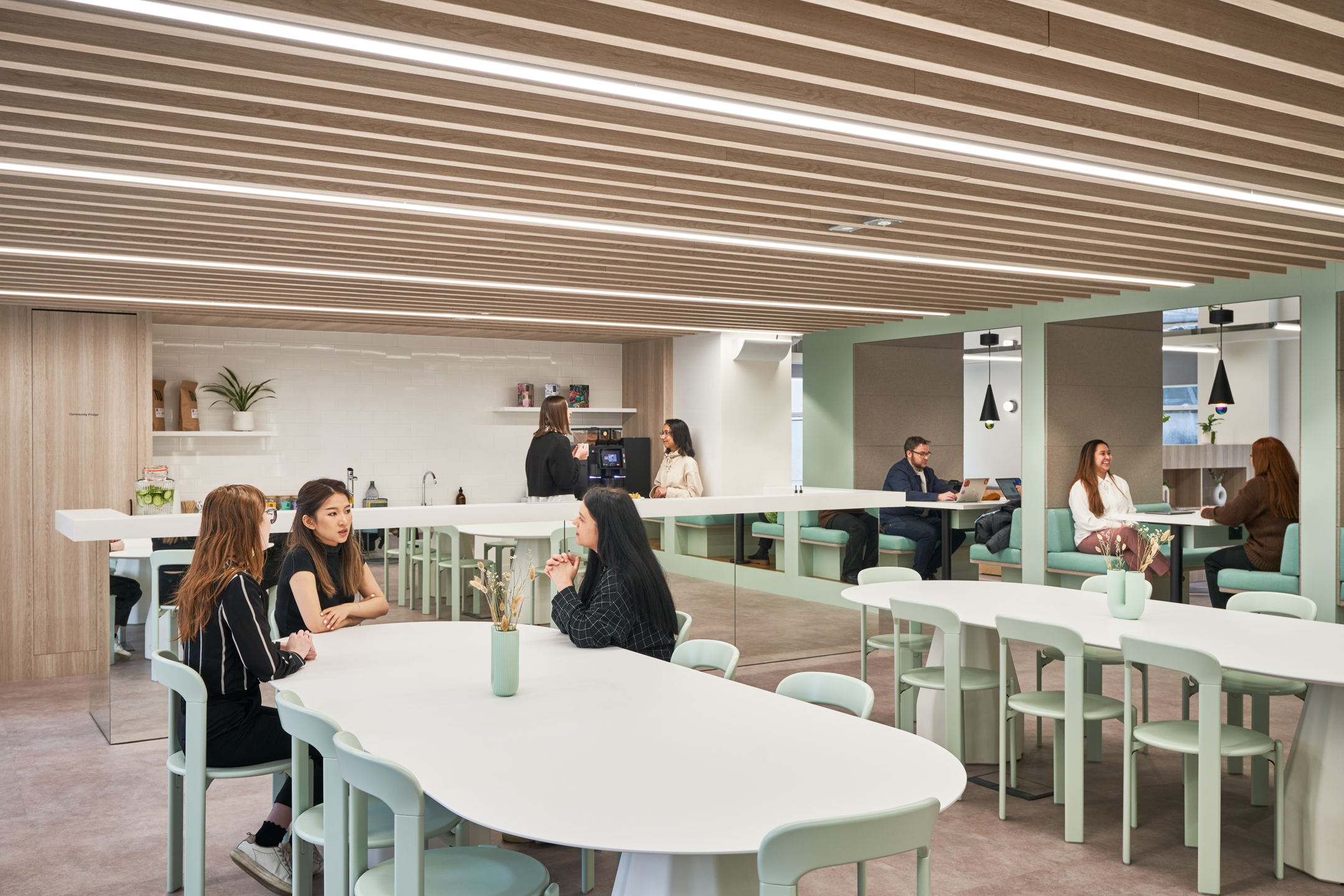 Flexible working zone at Huckletree Oxford Street with mint-toned furniture, café-style booths and communal tables, all curated by Platfform.