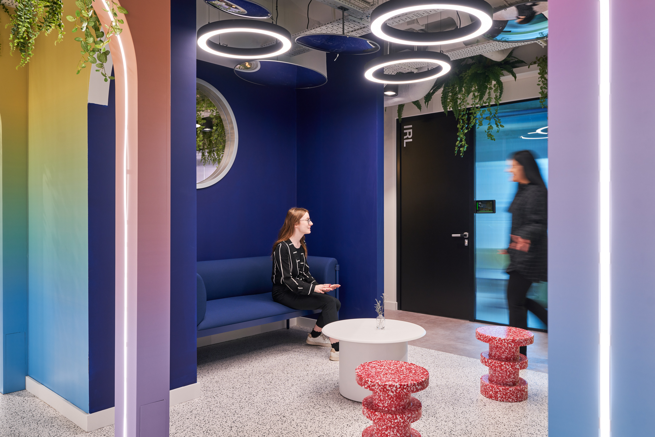 Vibrant lounge corner at Huckletree Oxford Street with a bold blue sofa, terrazzo stools and playful lighting, furnished by Platfform.